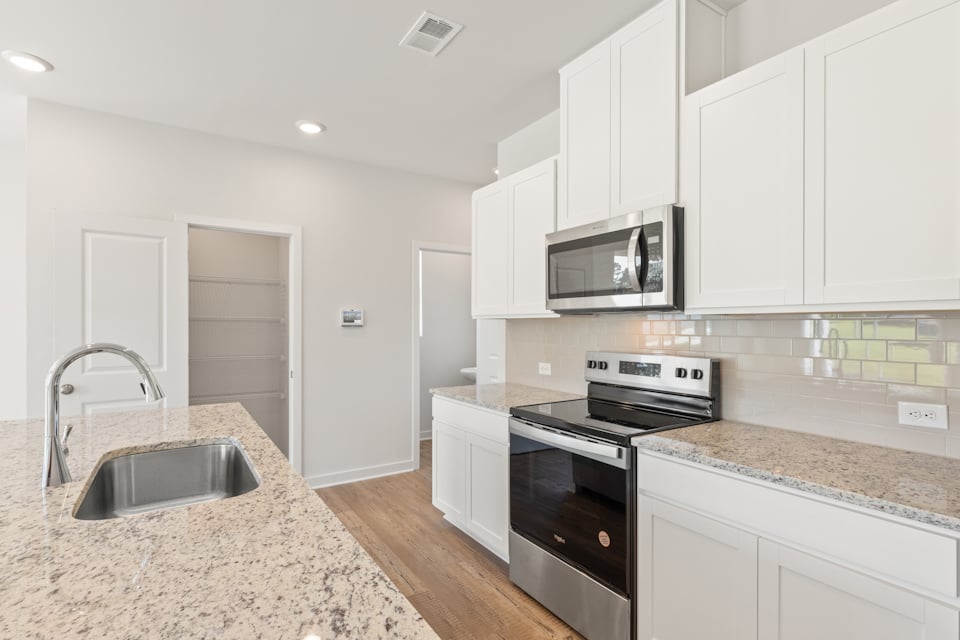 A kitchen with white cabinets.
