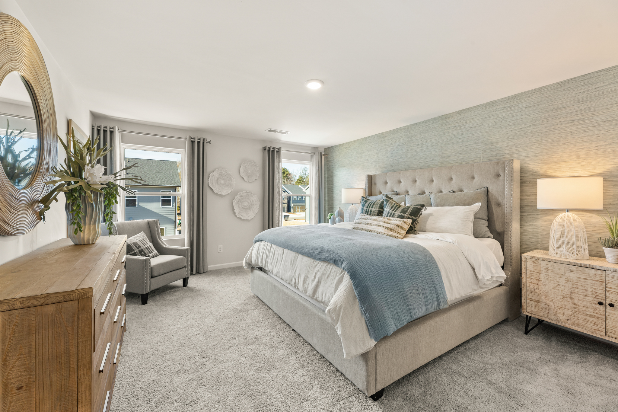 A bedroom with a bed and a chair.