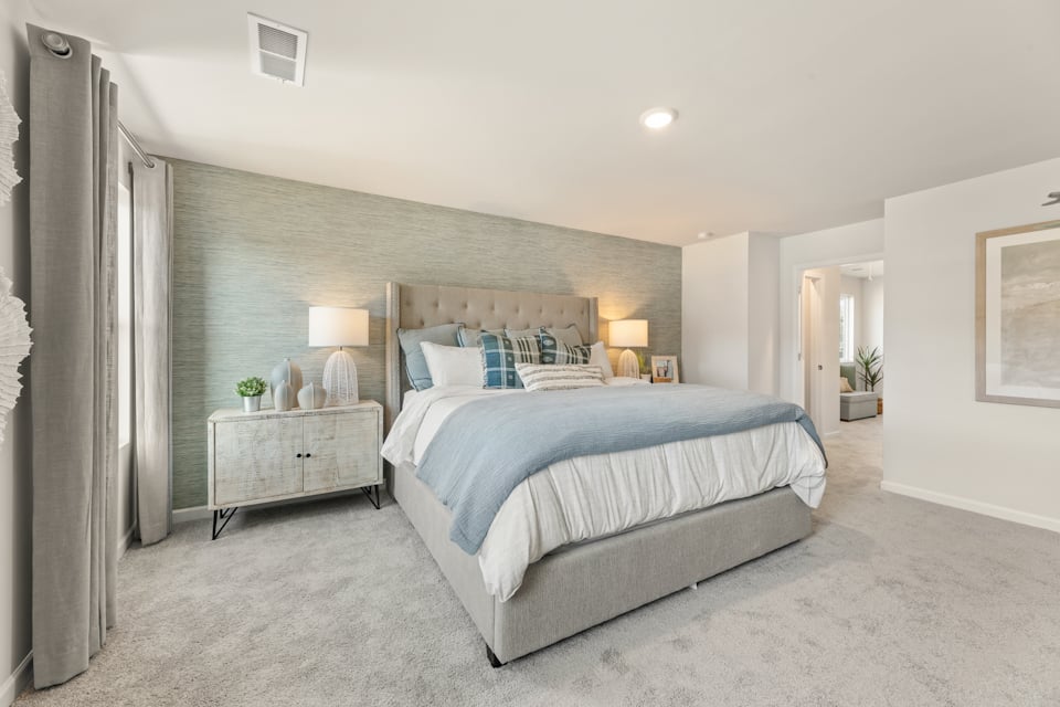 A bedroom with a bed and lamps.