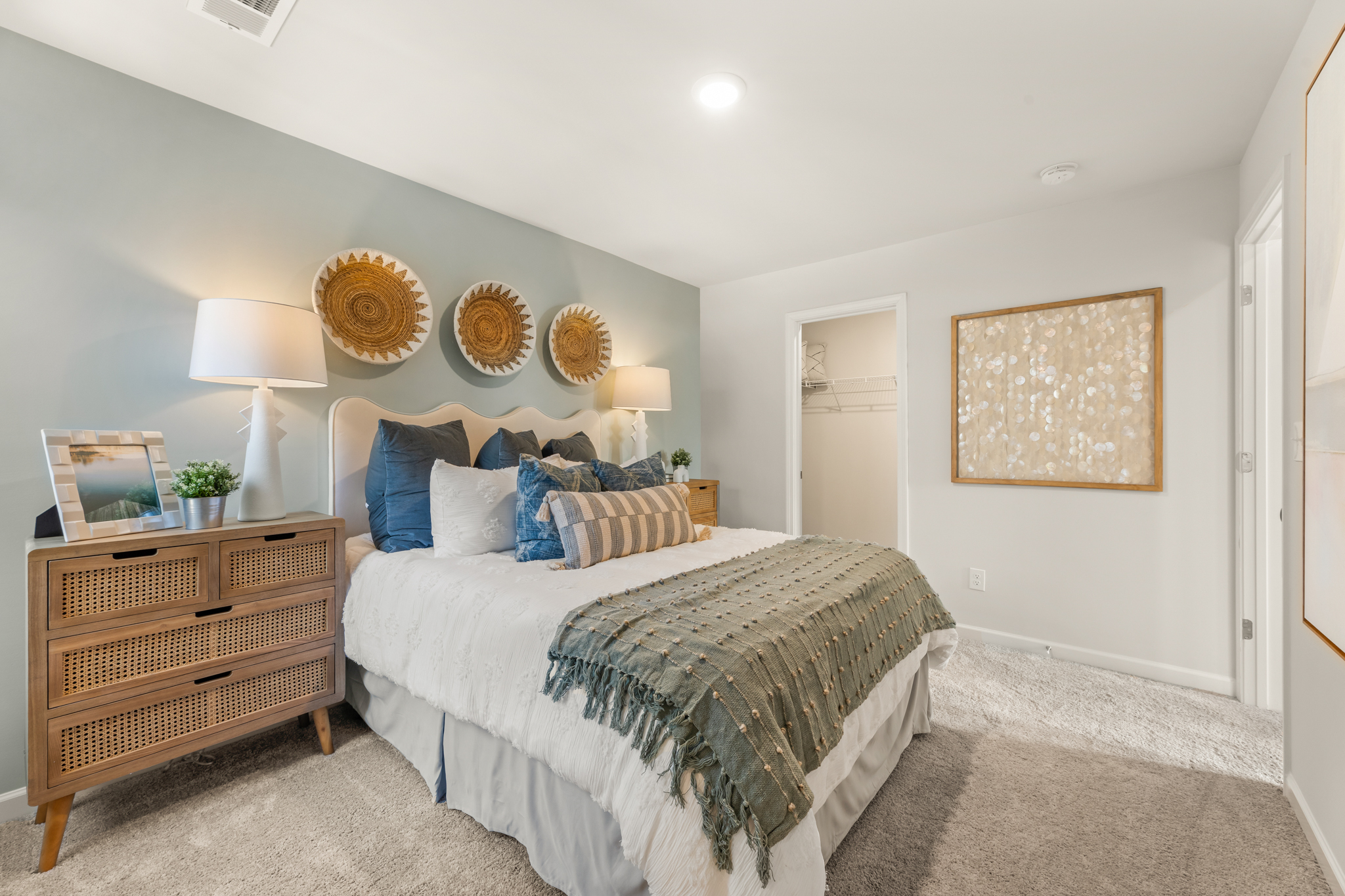 A bedroom with a bed and lamps.