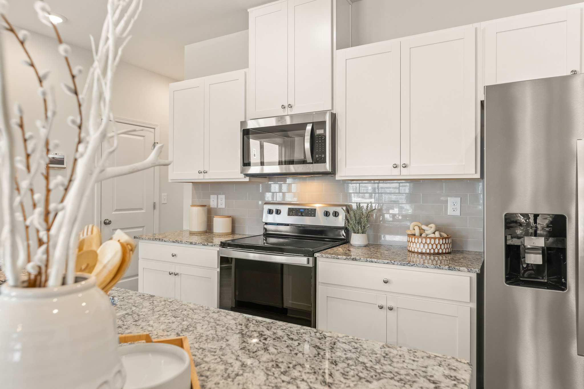 A kitchen with white cabinets.