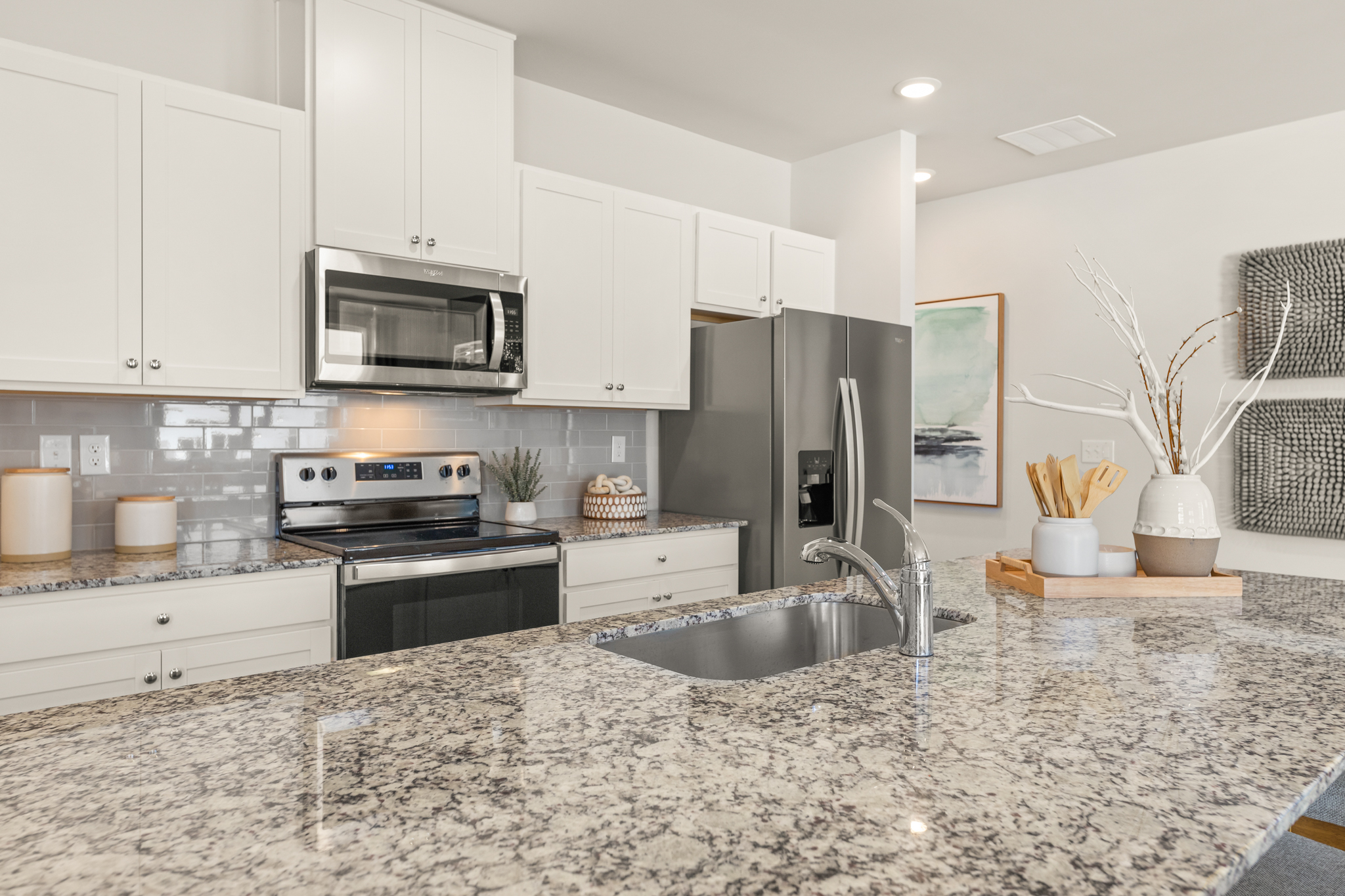 A kitchen with white cabinets.