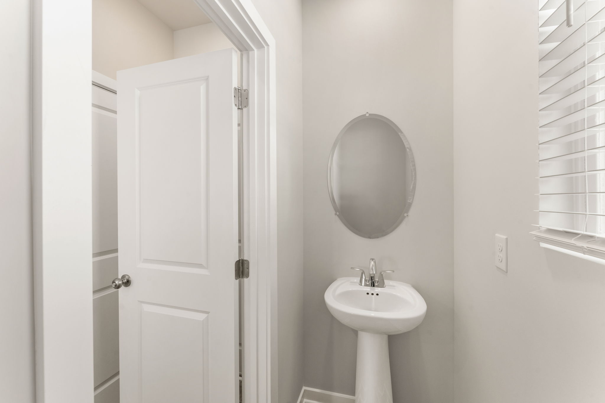 A bathroom with a round mirror.