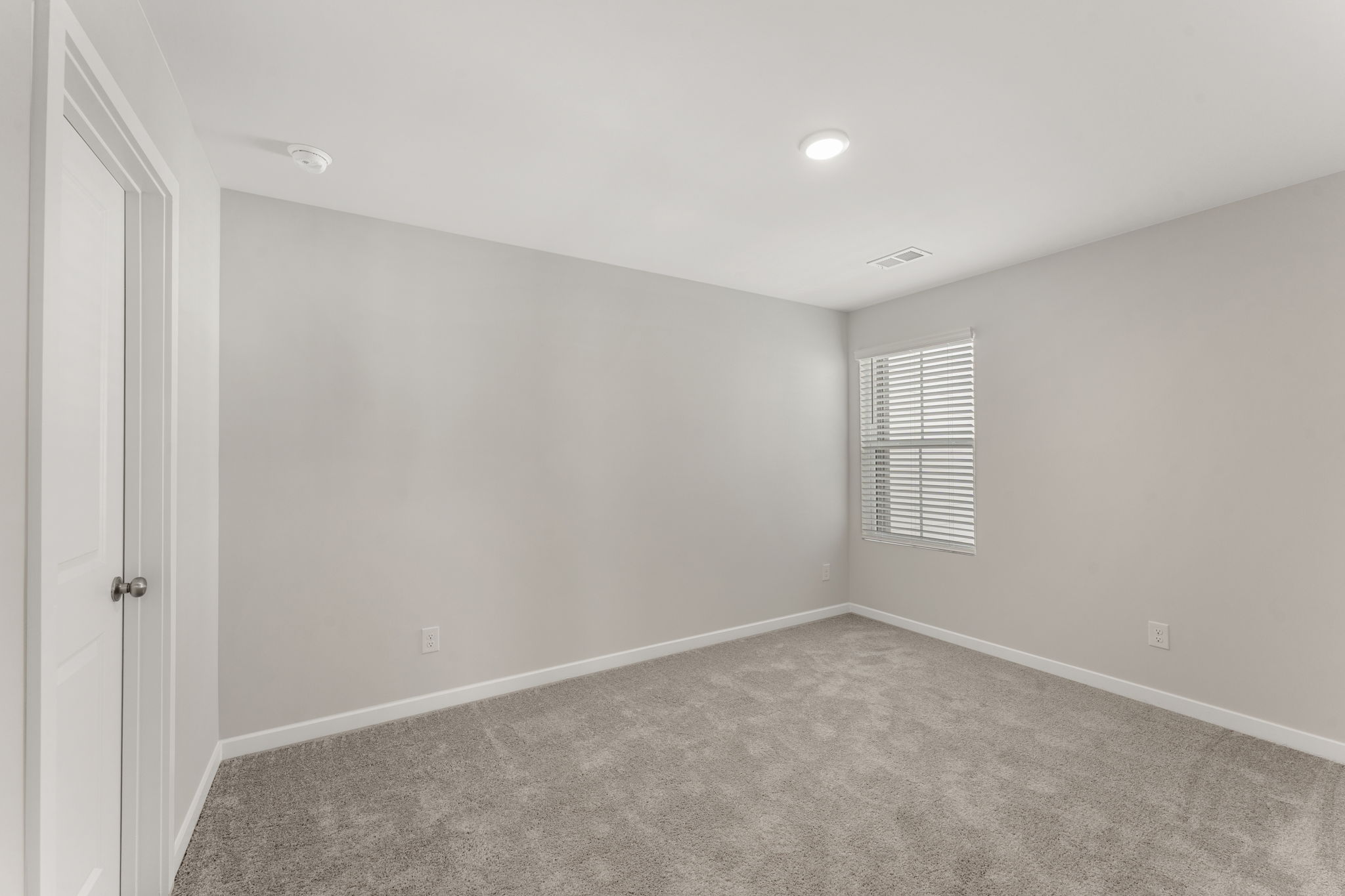 A room with a carpet and a window.
