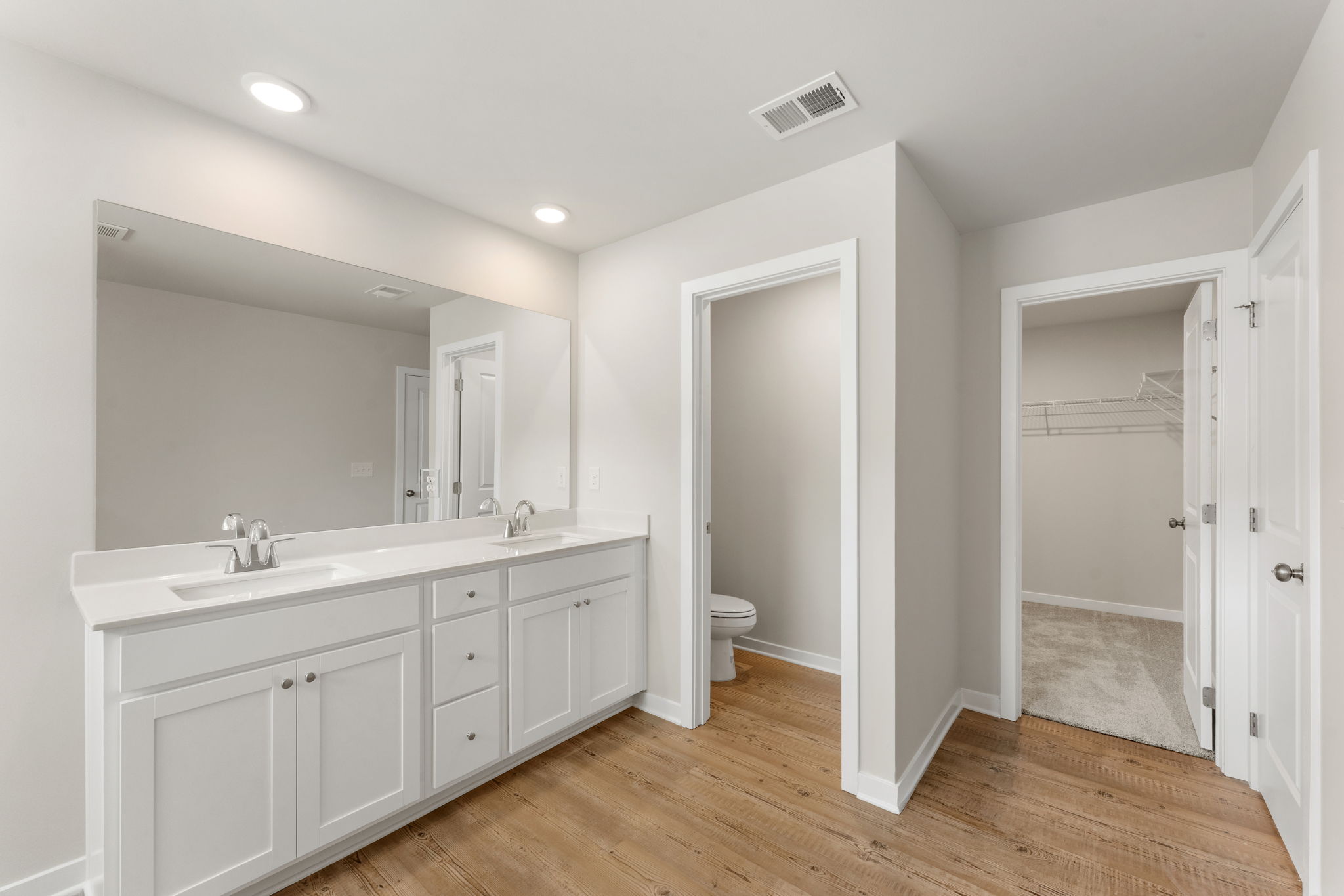 A bathroom with white cabinets.