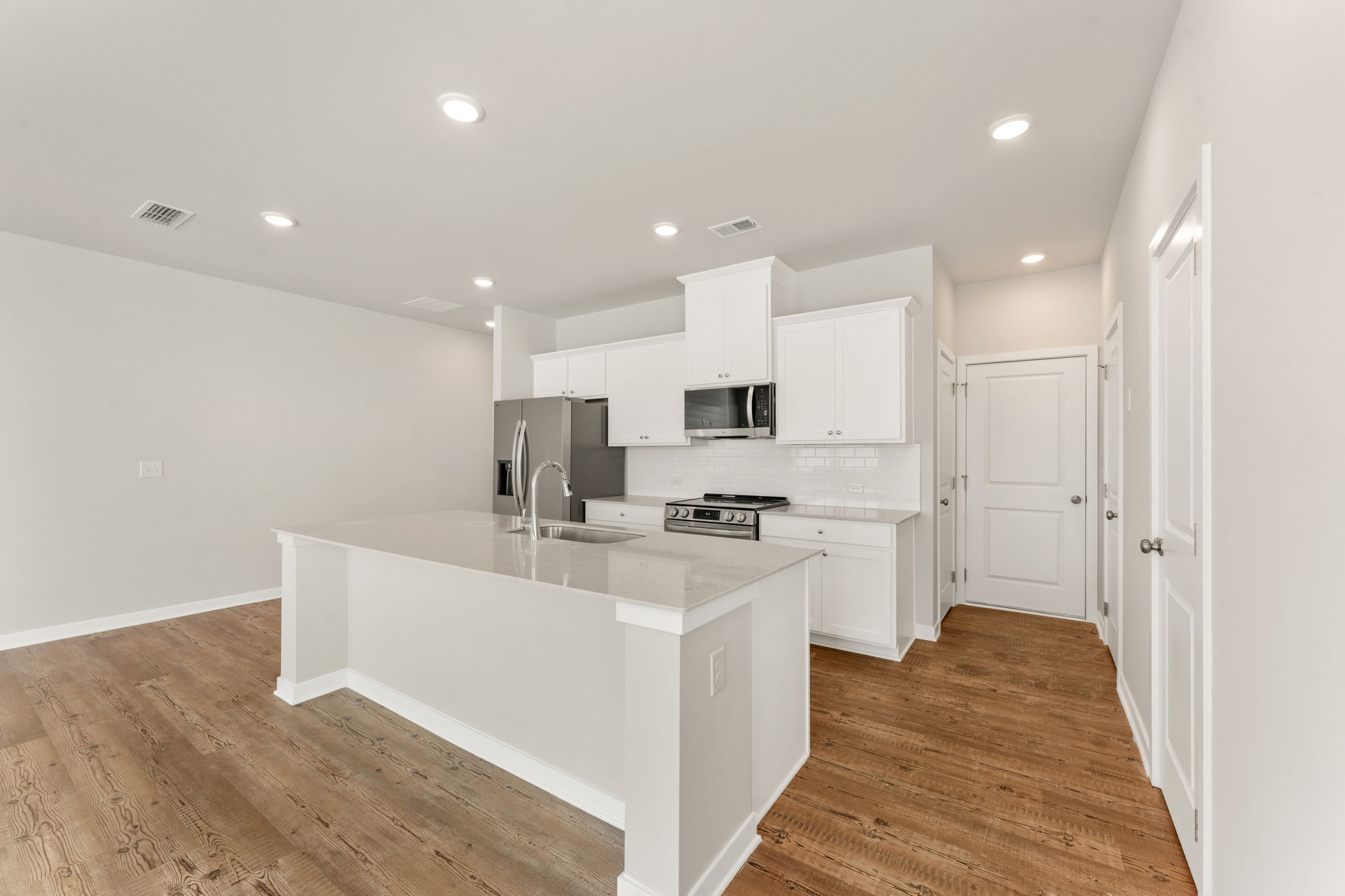 A kitchen with white cabinets.
