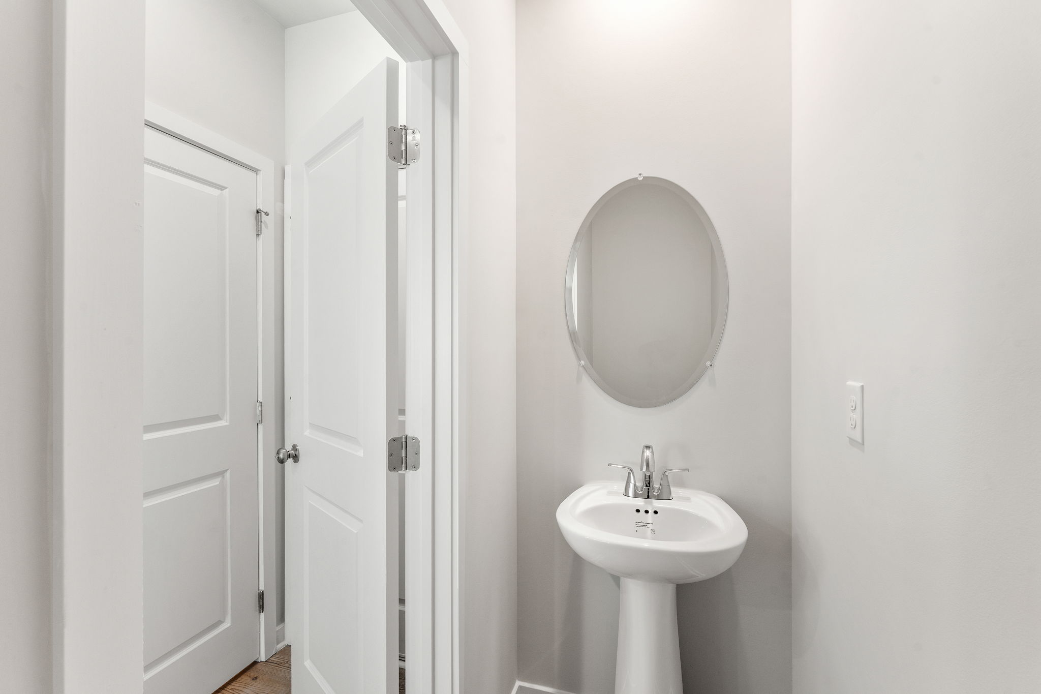 A bathroom with a round mirror.