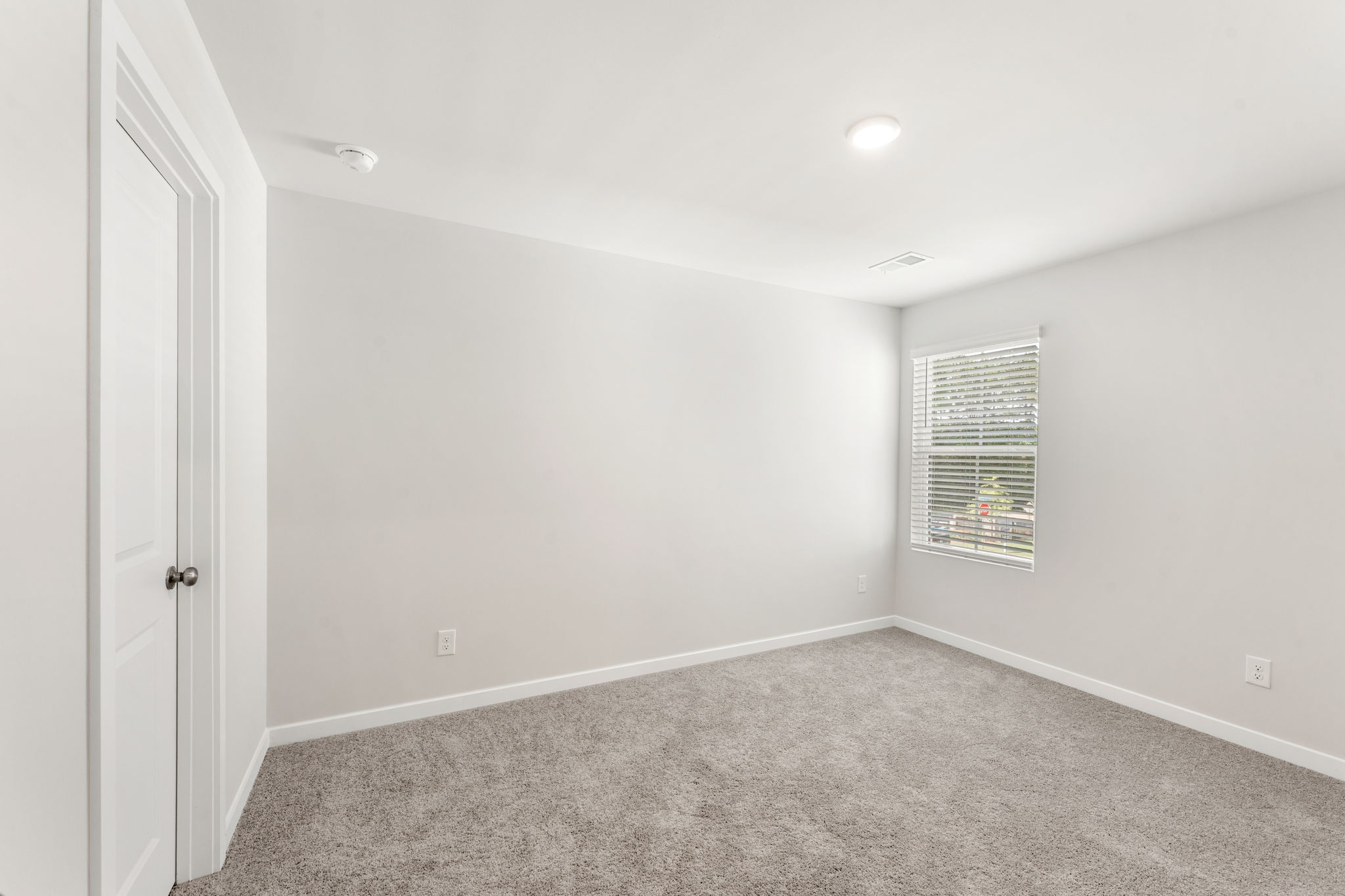 A room with a carpet and a window.