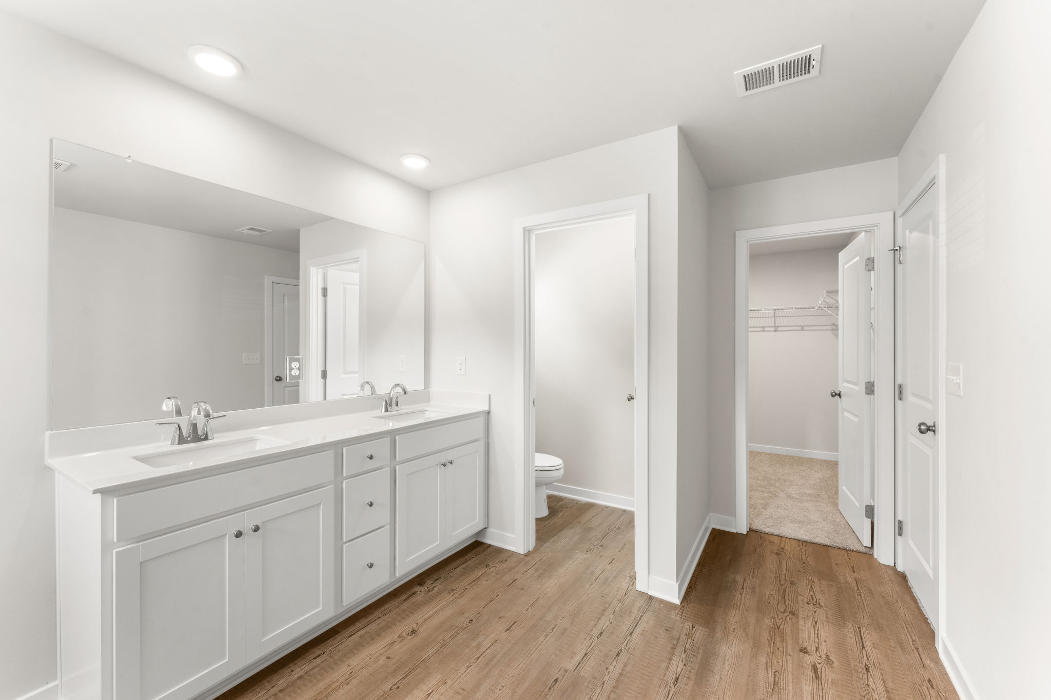 A bathroom with white cabinets.