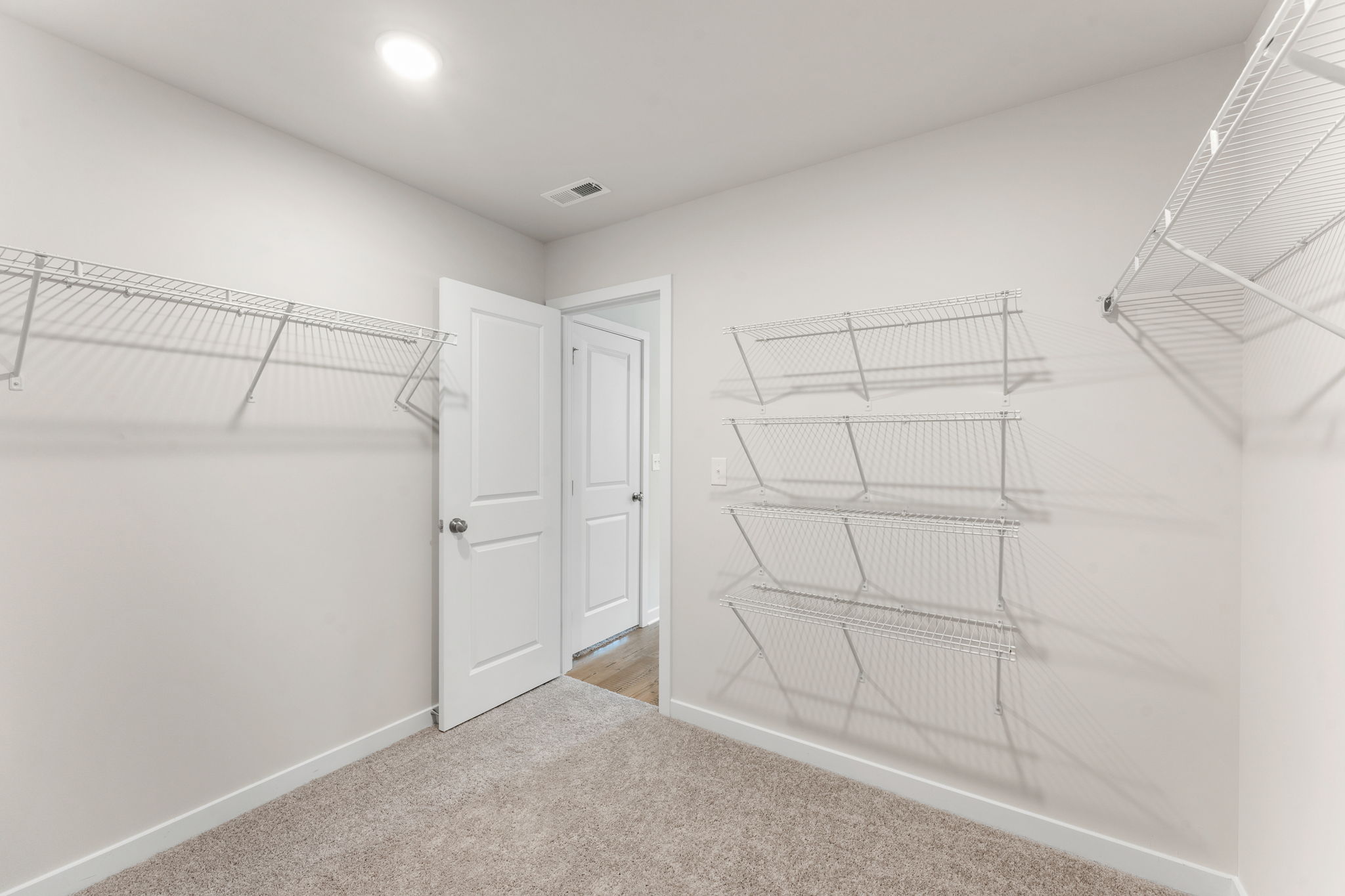 A white room with a cage and a white door.