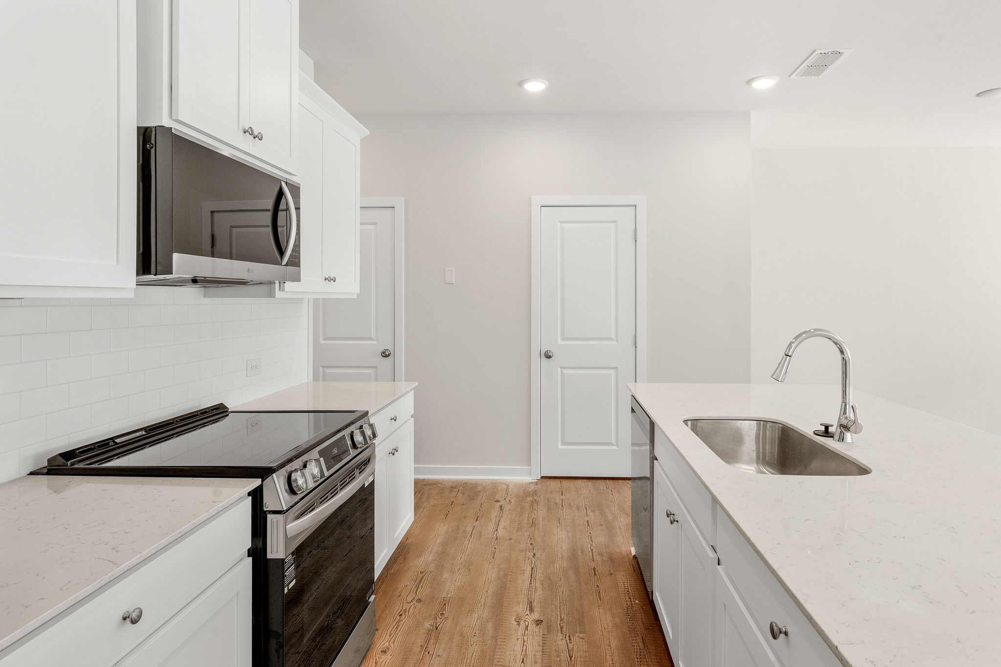 A kitchen with white cabinets.
