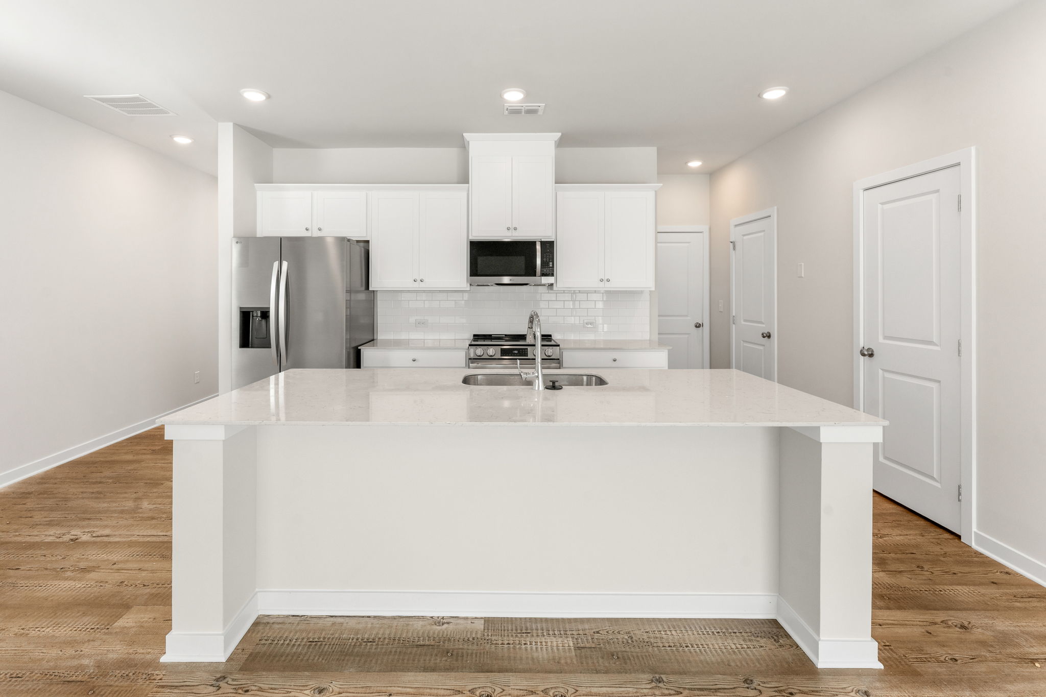 A kitchen with white cabinets.