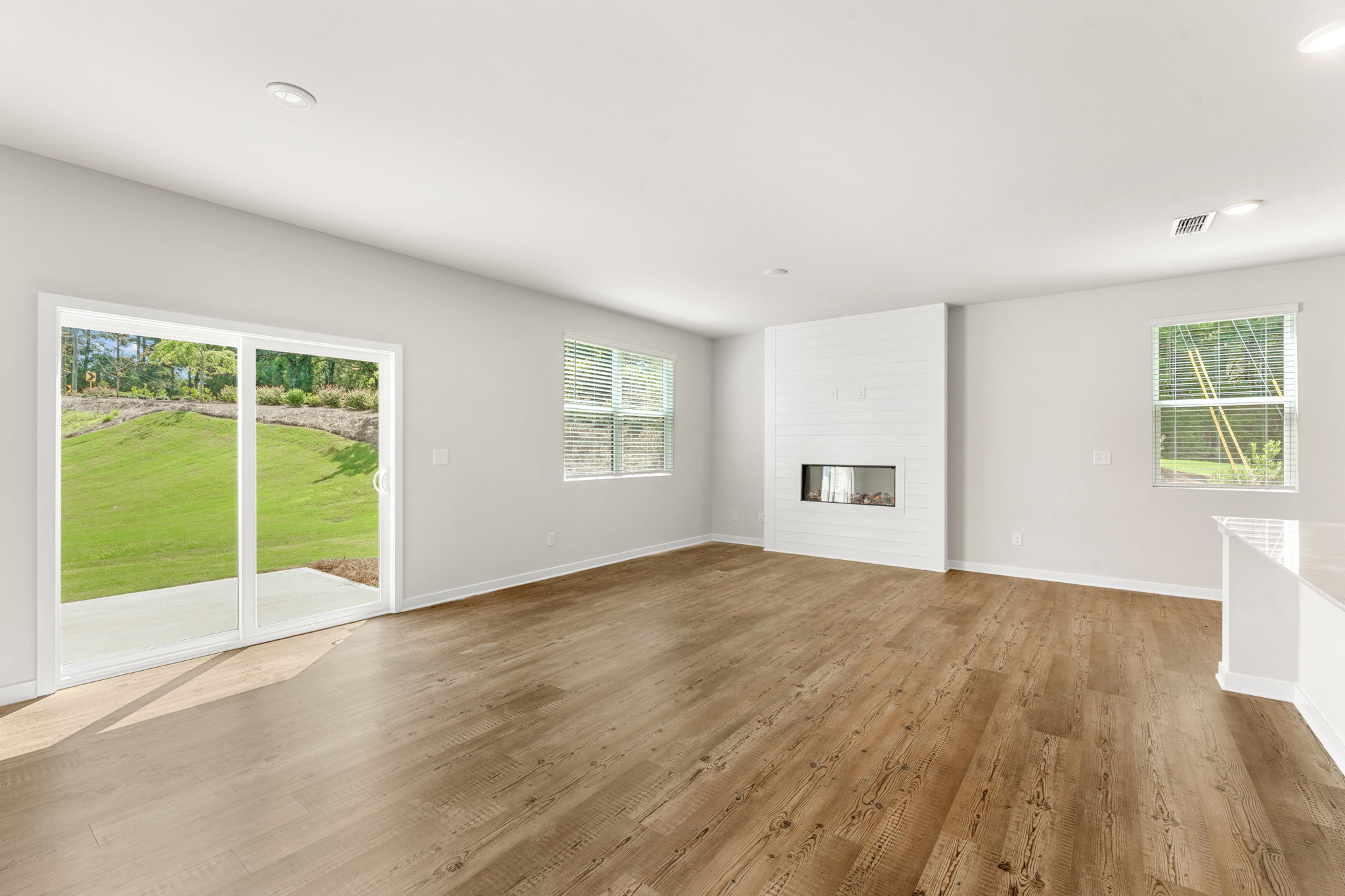 A room with a wood floor and a wood floor with a window.