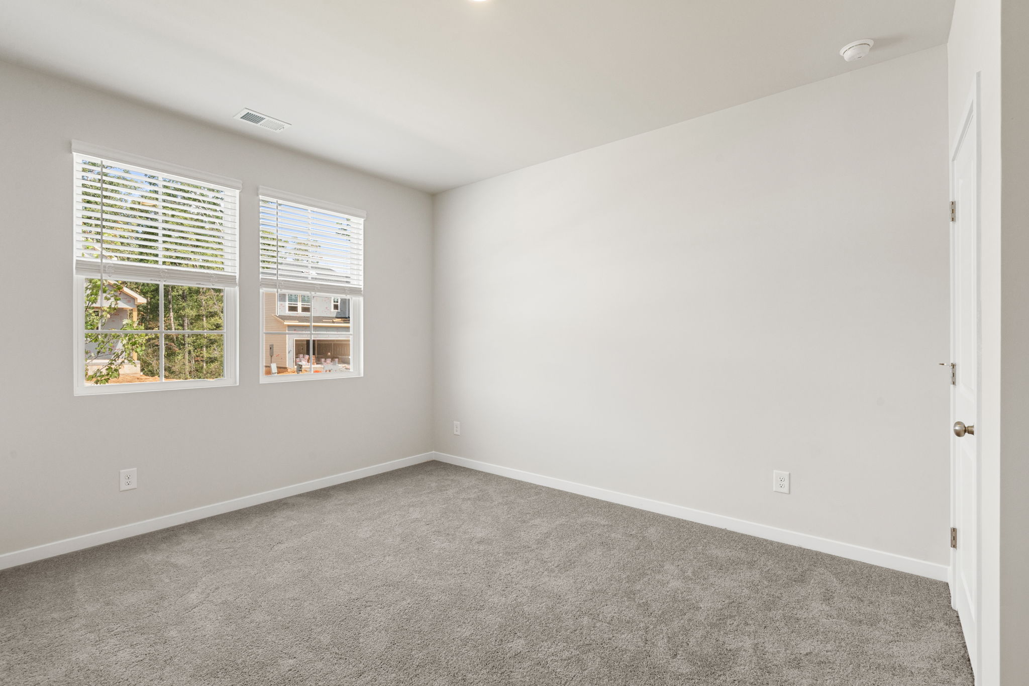 A room with windows and carpet.