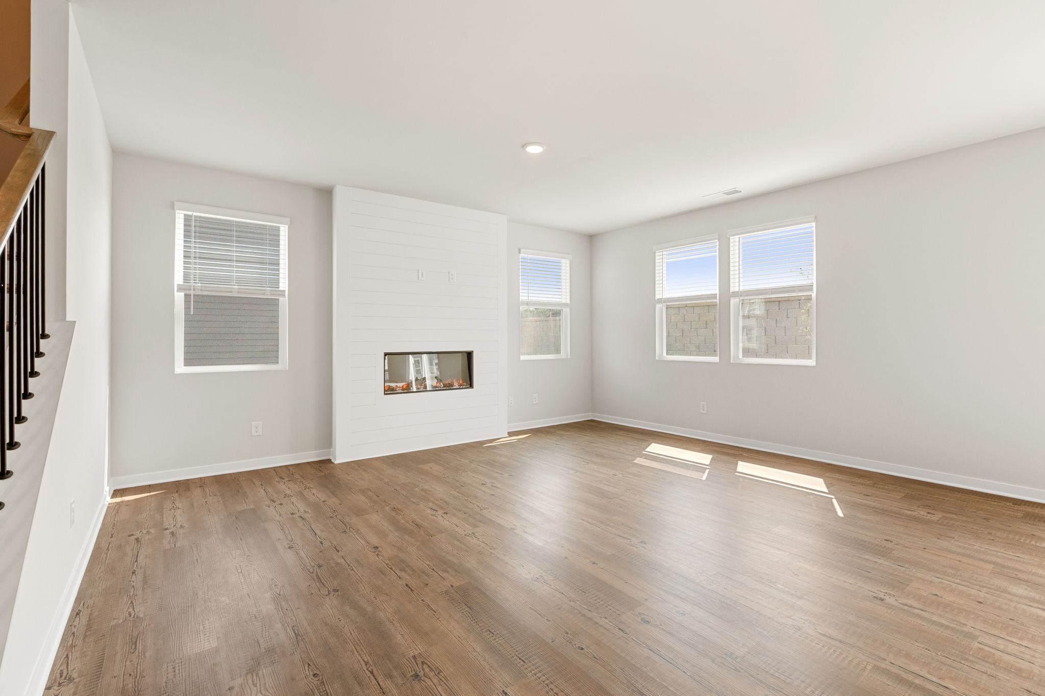 A room with a wood floor and a wood floor with a fireplace.