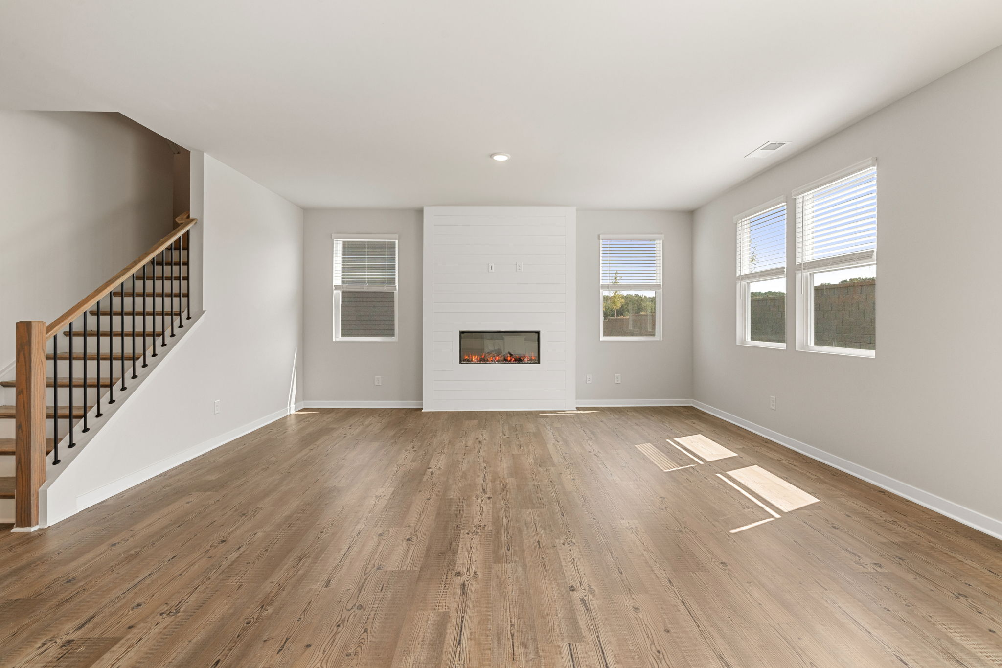 A room with a wood floor and windows.