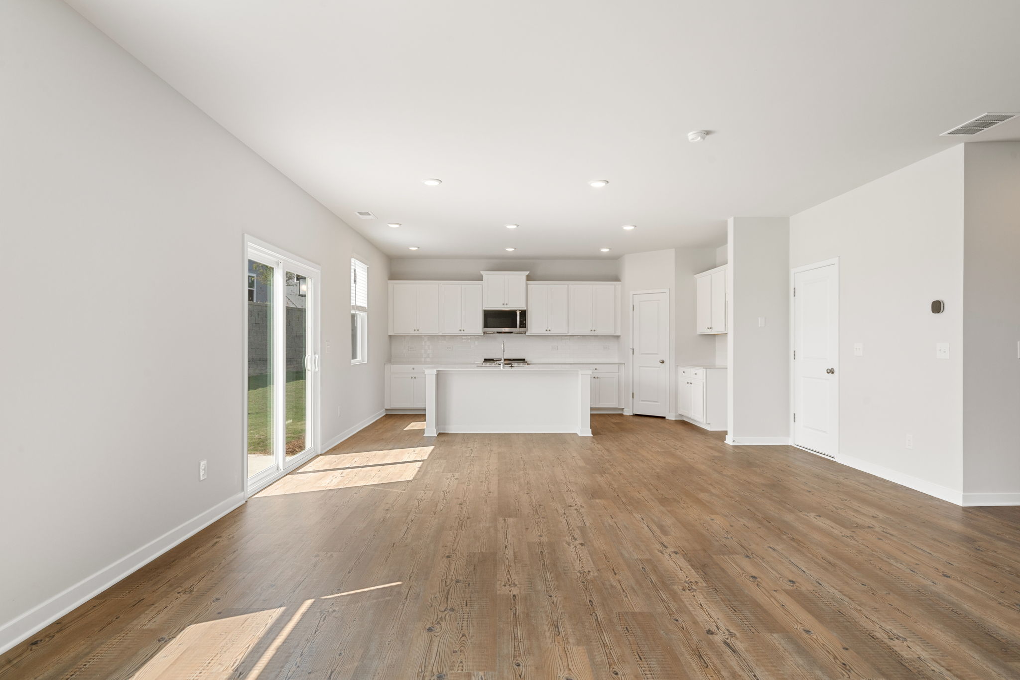 A large empty room with white cabinets.