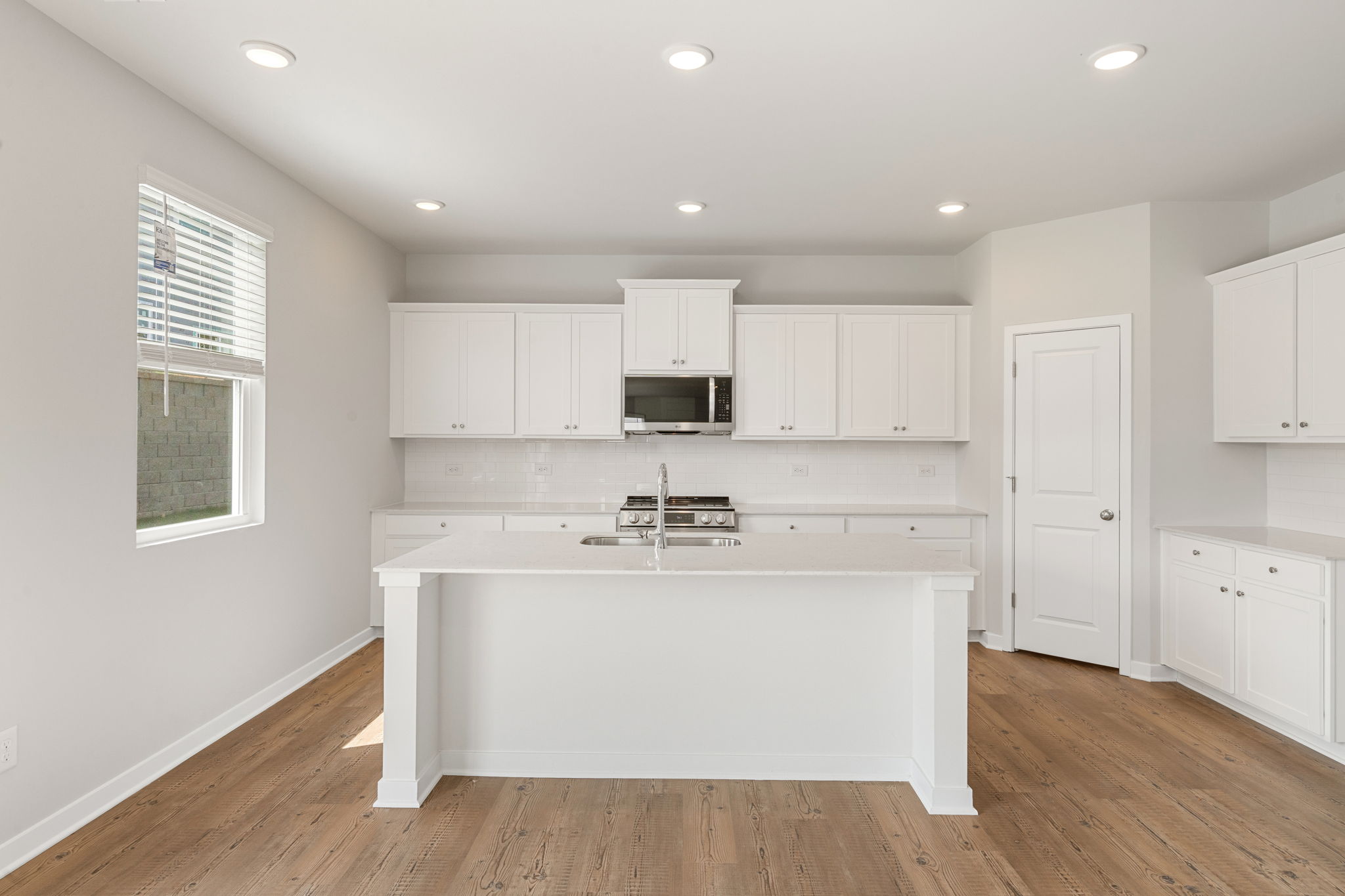 A kitchen with white cabinets.