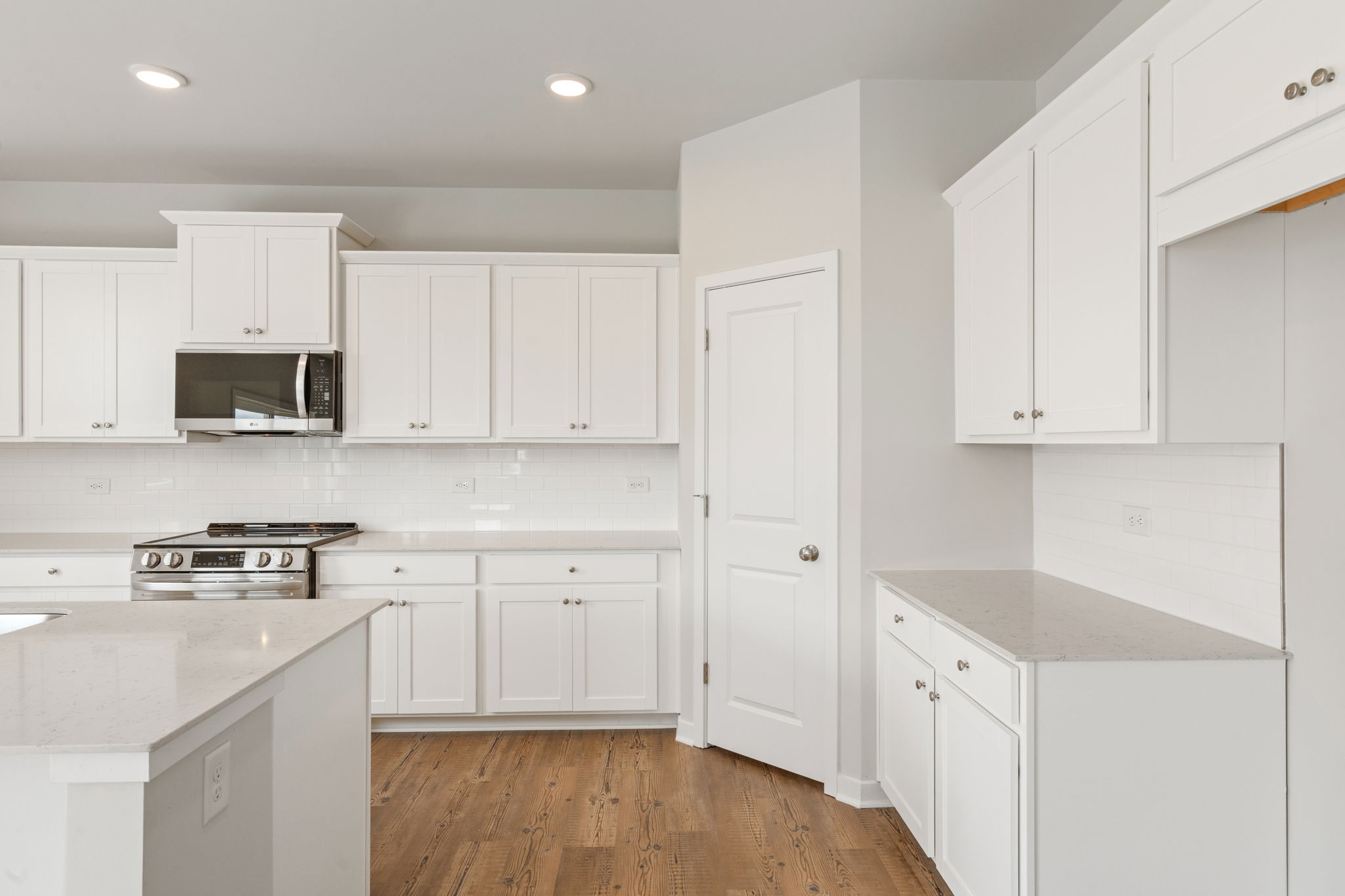A kitchen with white cabinets.