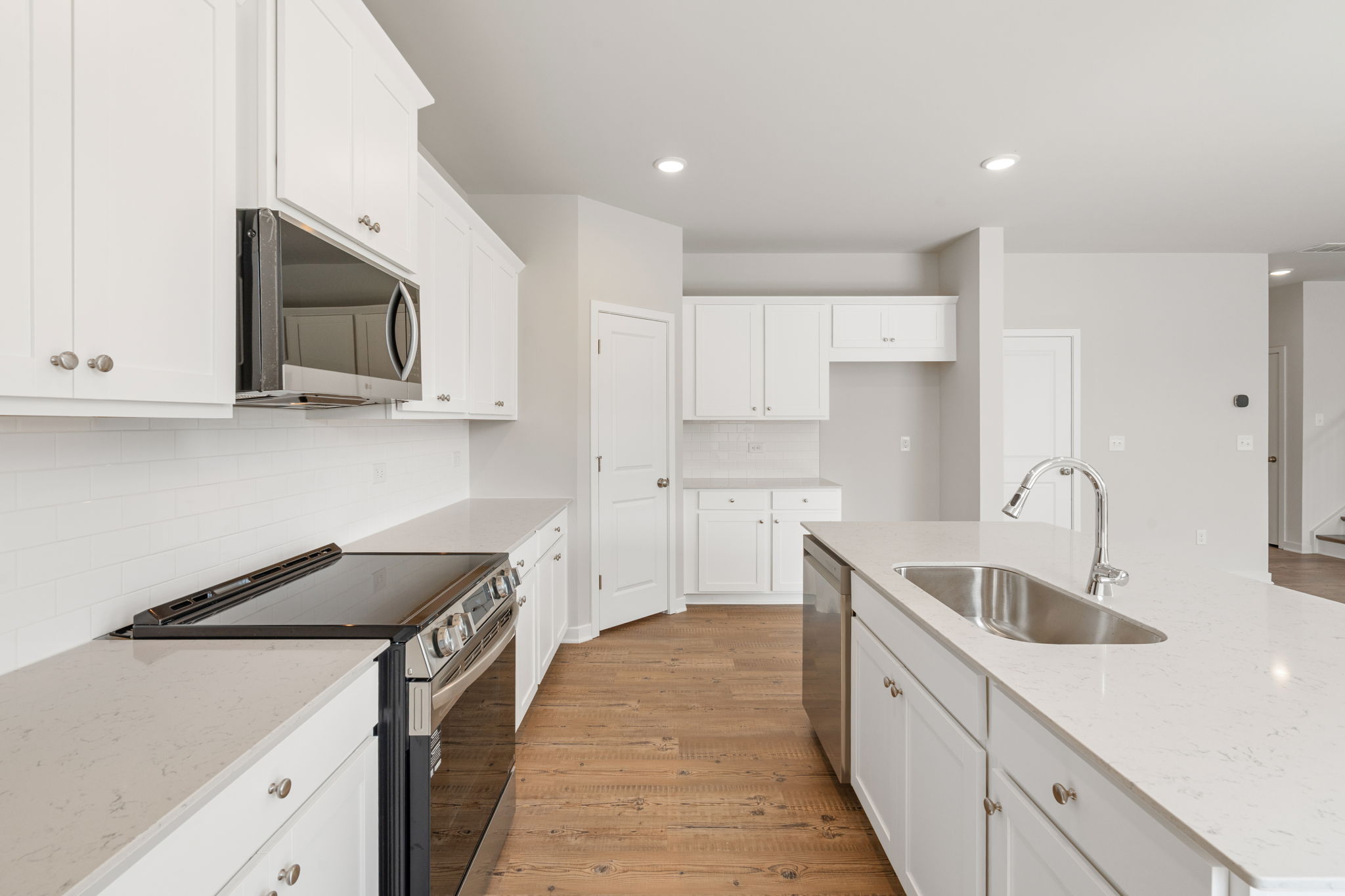 A kitchen with white cabinets.
