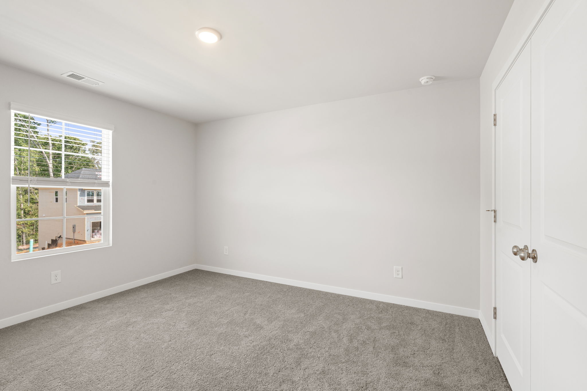 A room with a window and a carpet.