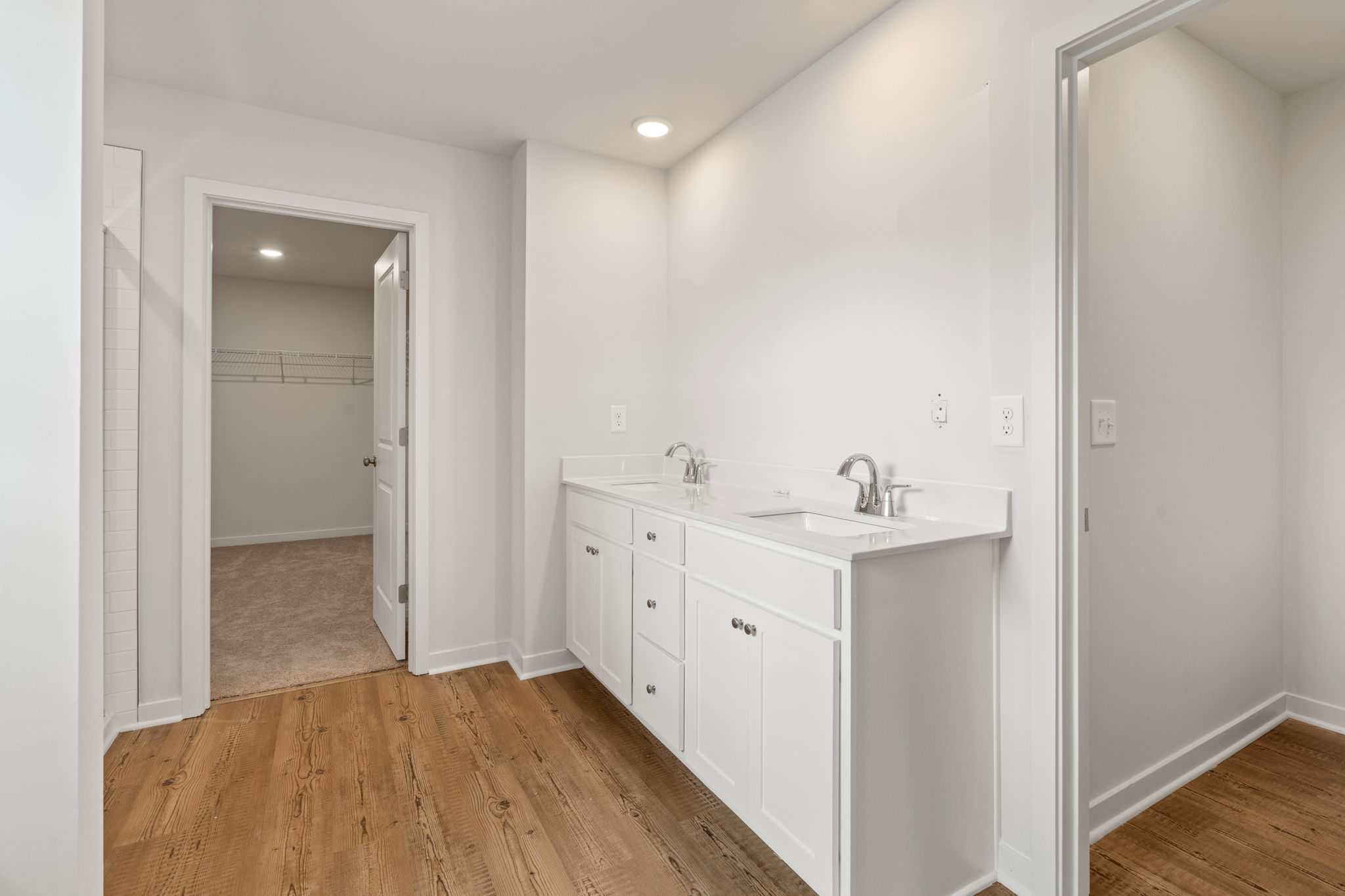 A bathroom with white cabinets.