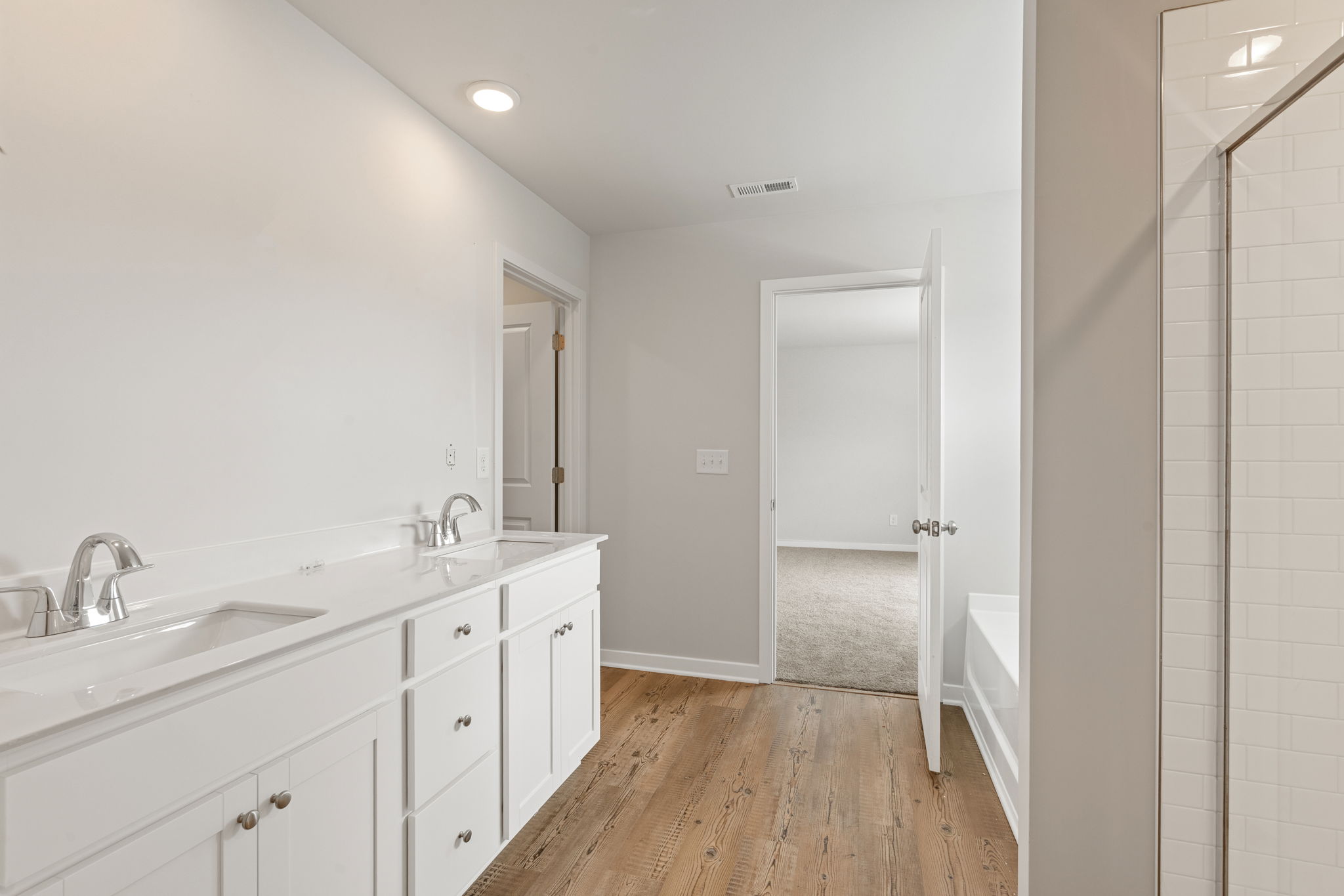 A bathroom with white cabinets.