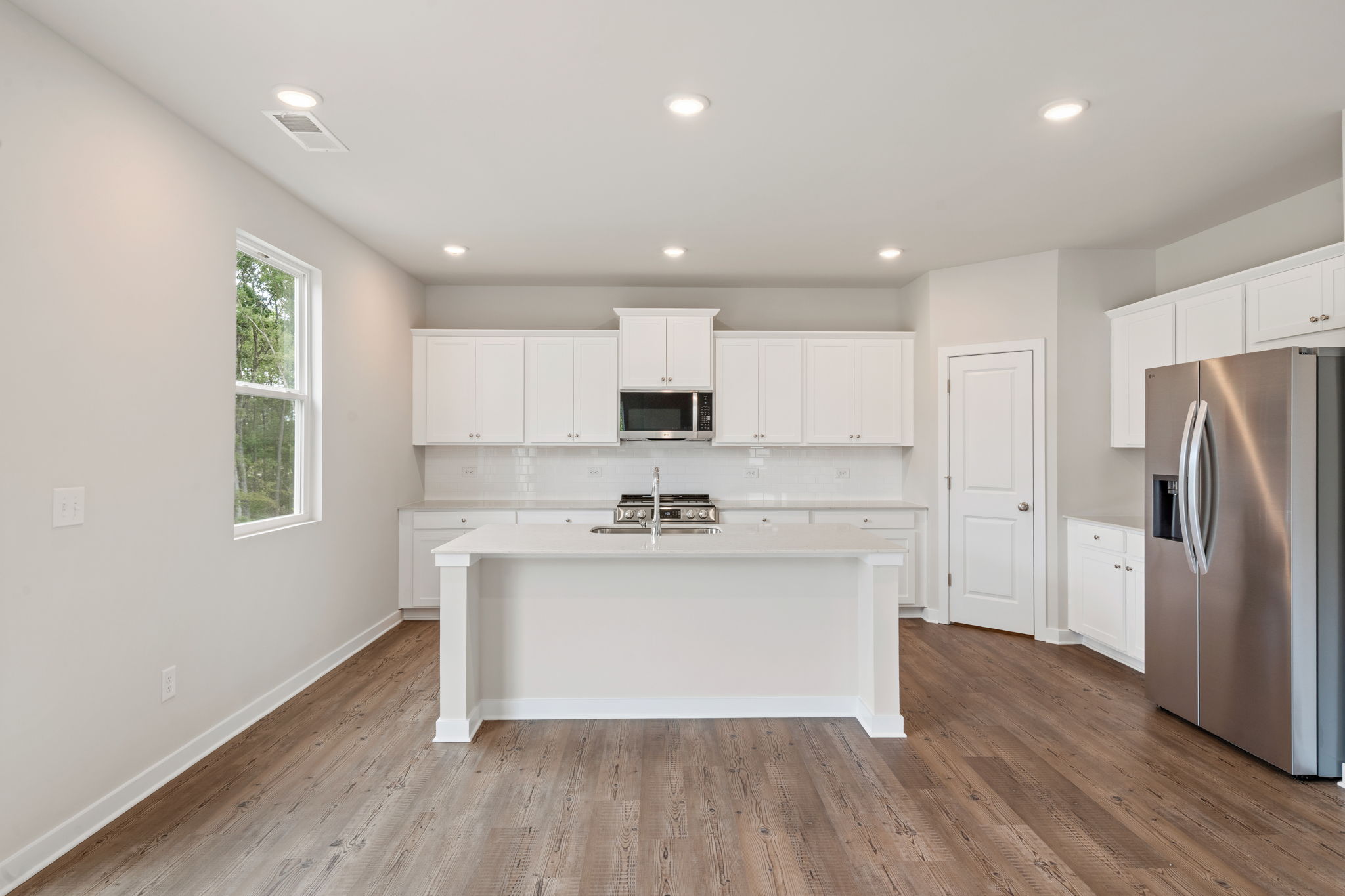 A kitchen with white cabinets.