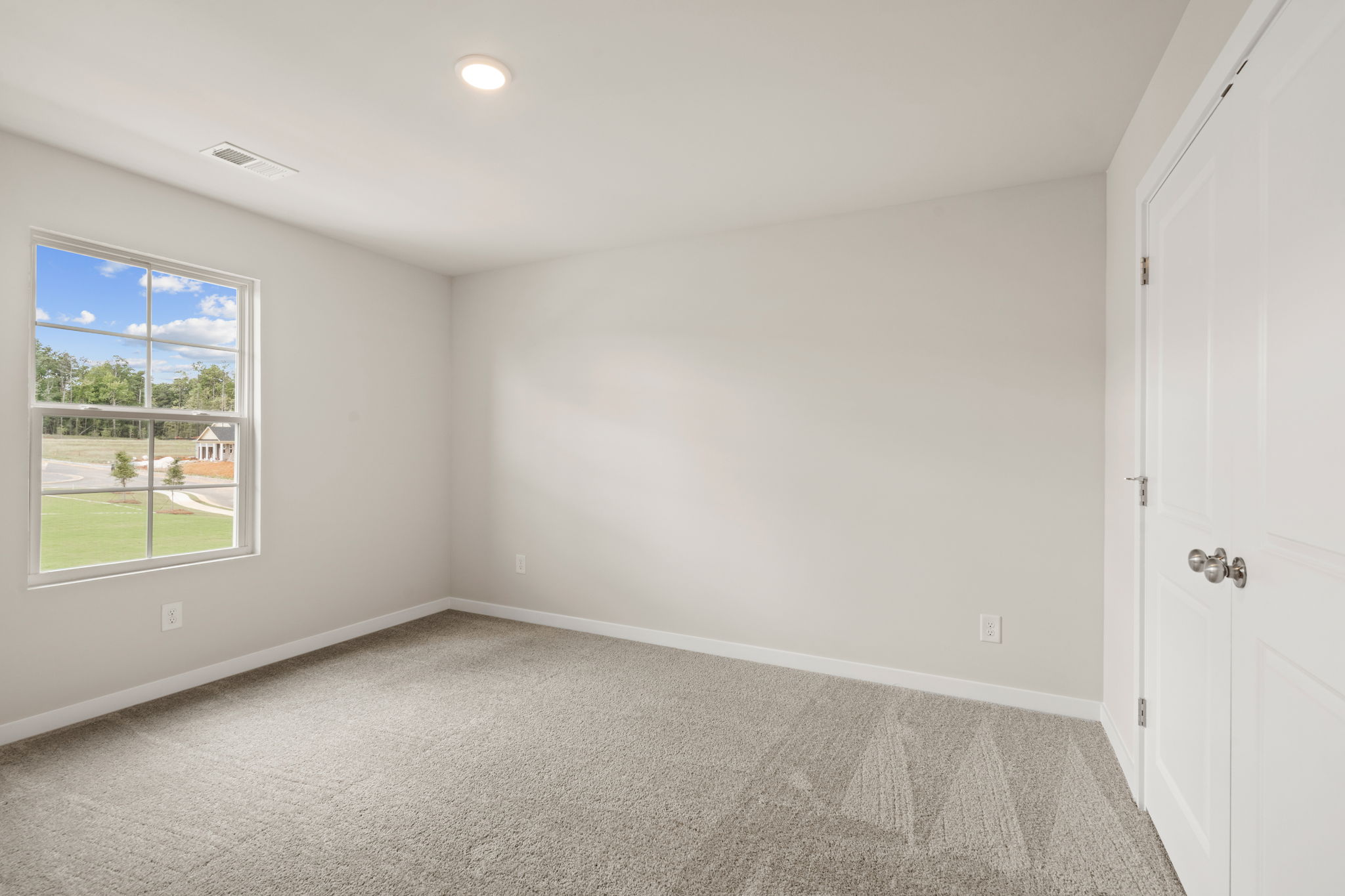A room with a window and a carpet.