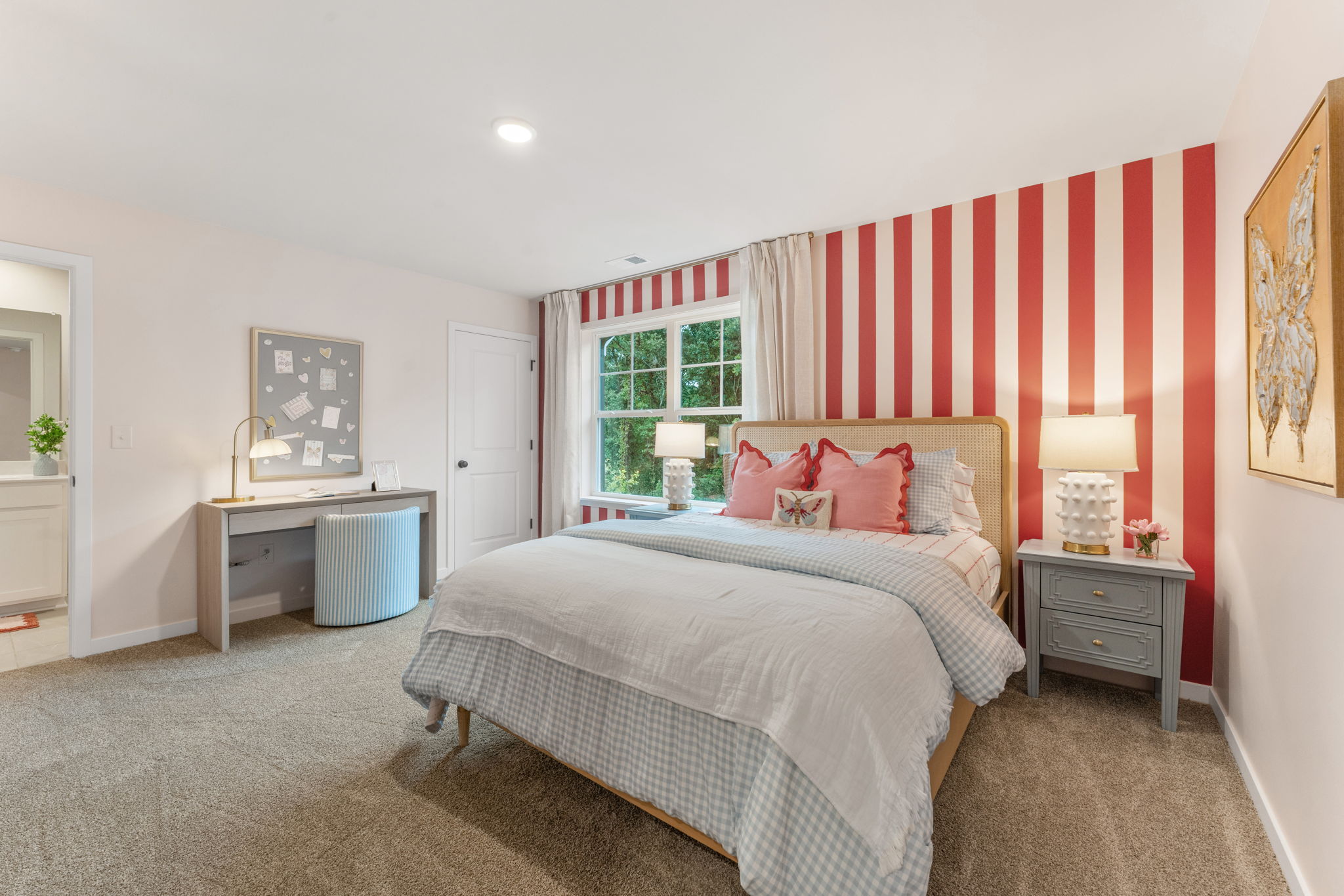 A bedroom with a bed and a red and white striped curtain.