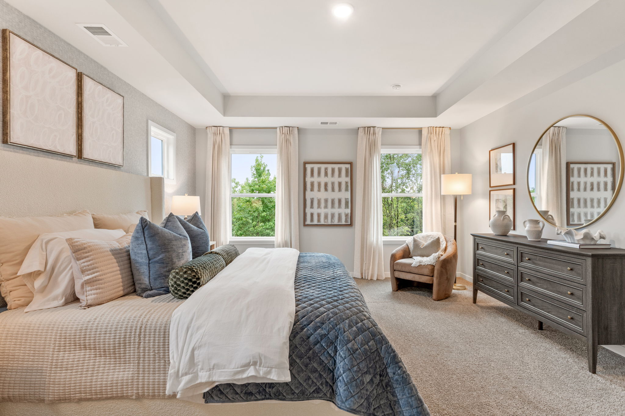 A bedroom with a bed and a mirror.