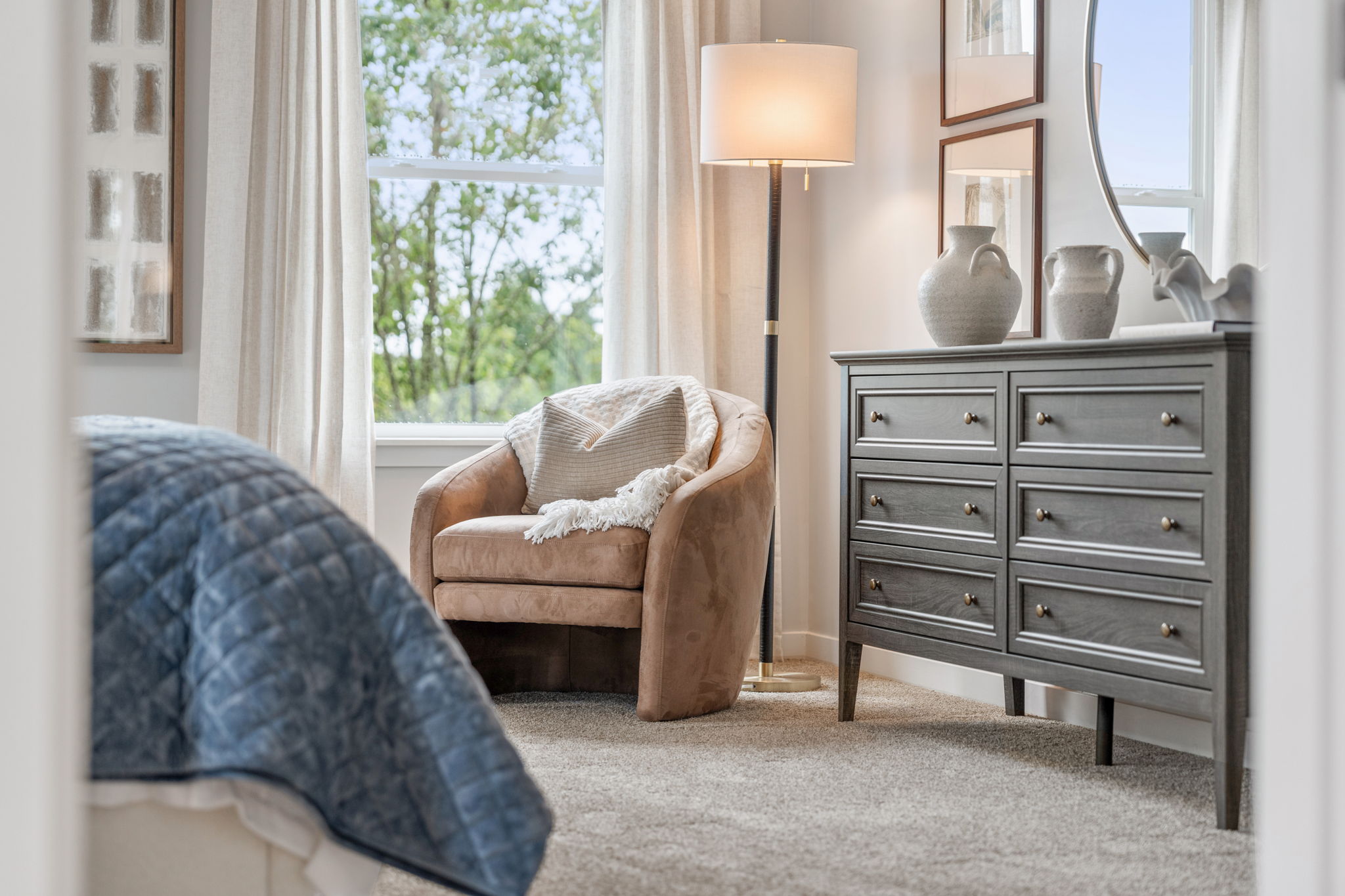 A room with a chair and a dresser.