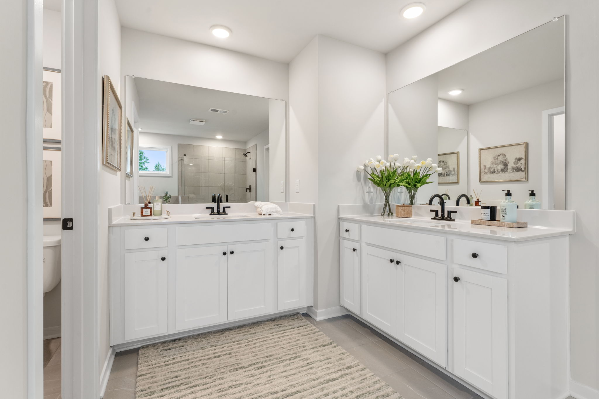 A bathroom with white cabinets.