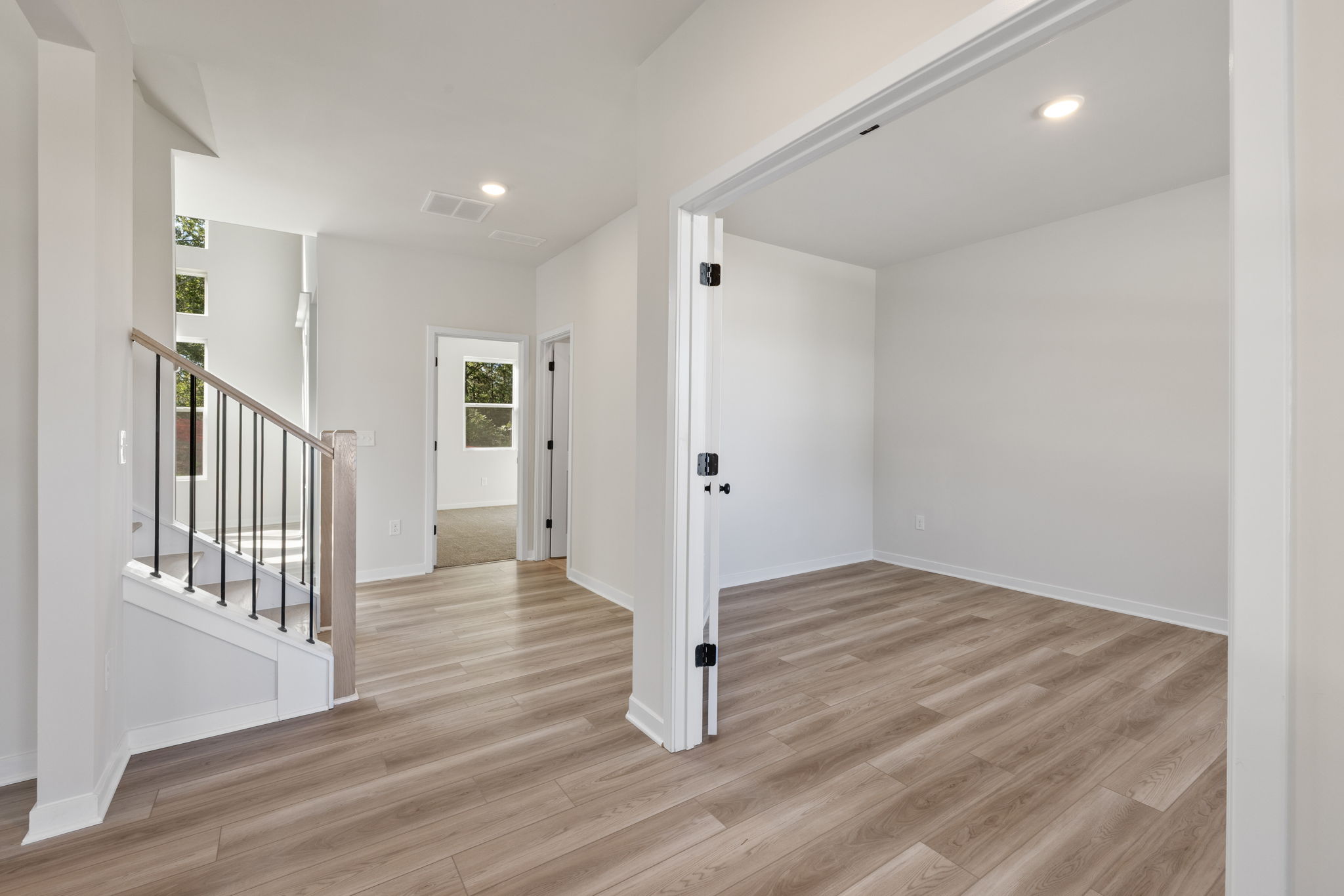 A room with white walls and wood floors.