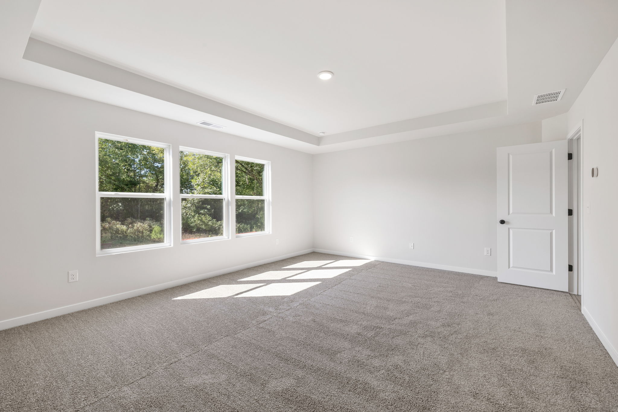 A room with a carpet and a window.