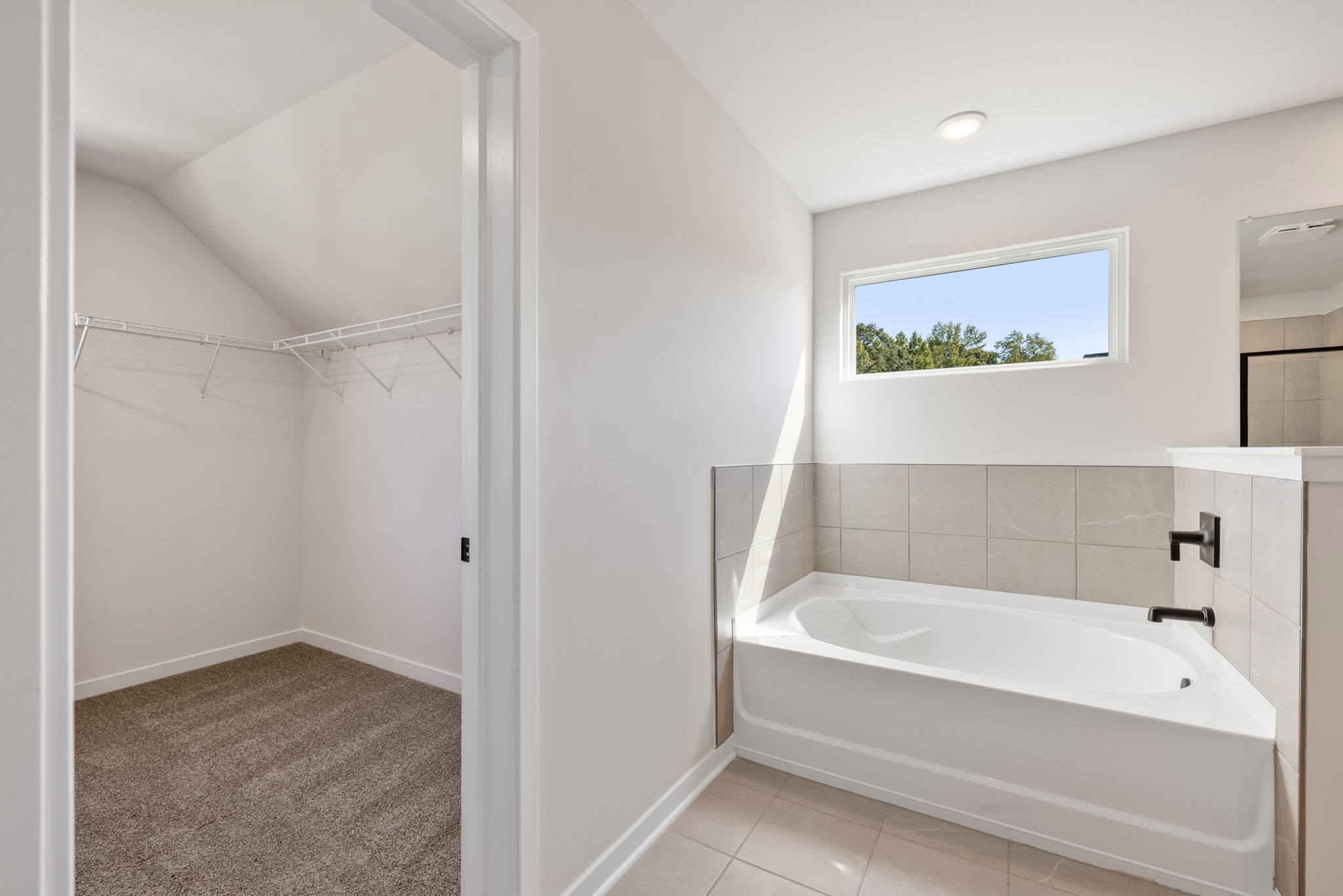 A bathroom with a tub and a window.