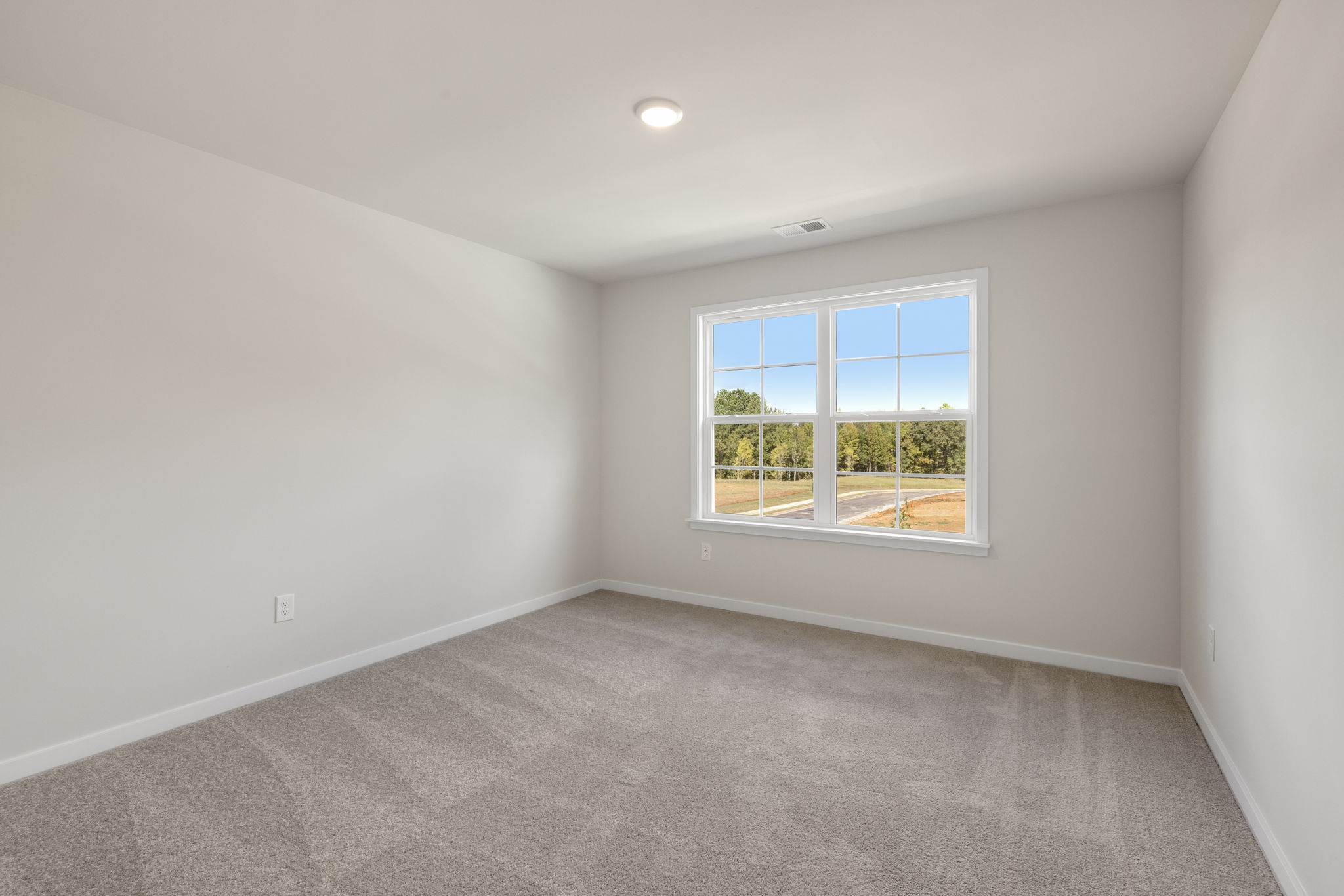 A room with a window and a carpet.