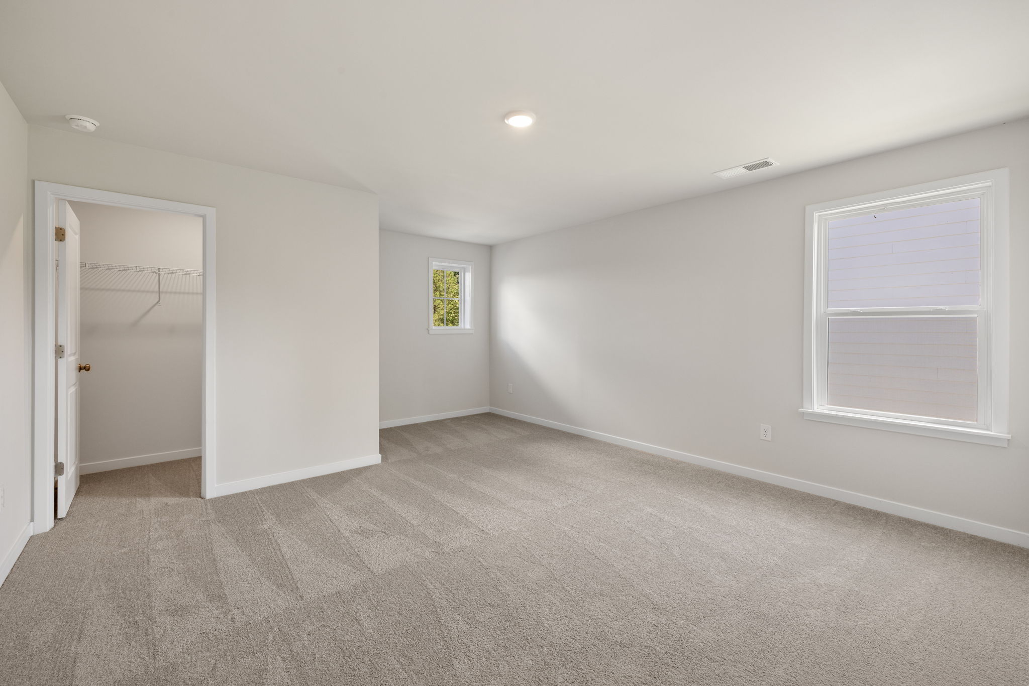 A room with a carpet and a door.