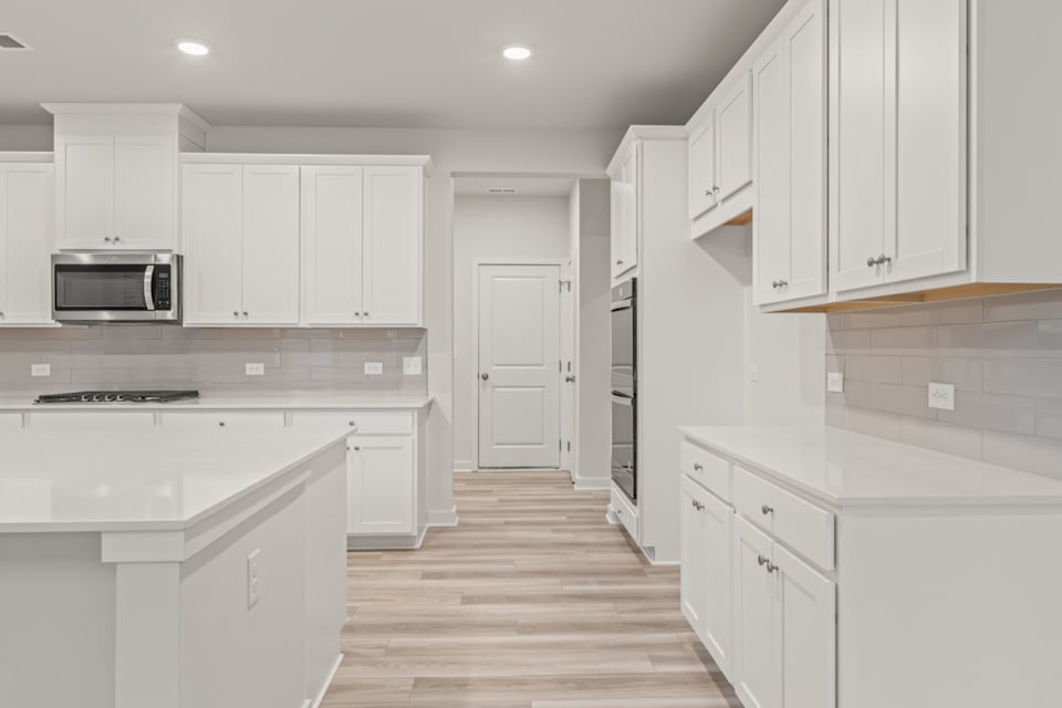 A kitchen with white cabinets.