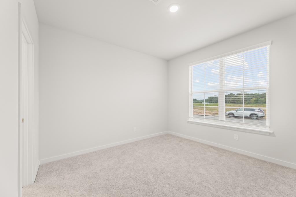 A room with a window and a car parked in it.