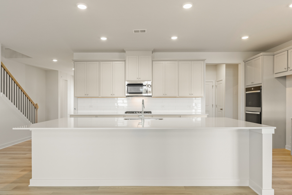 A kitchen with white cabinets.