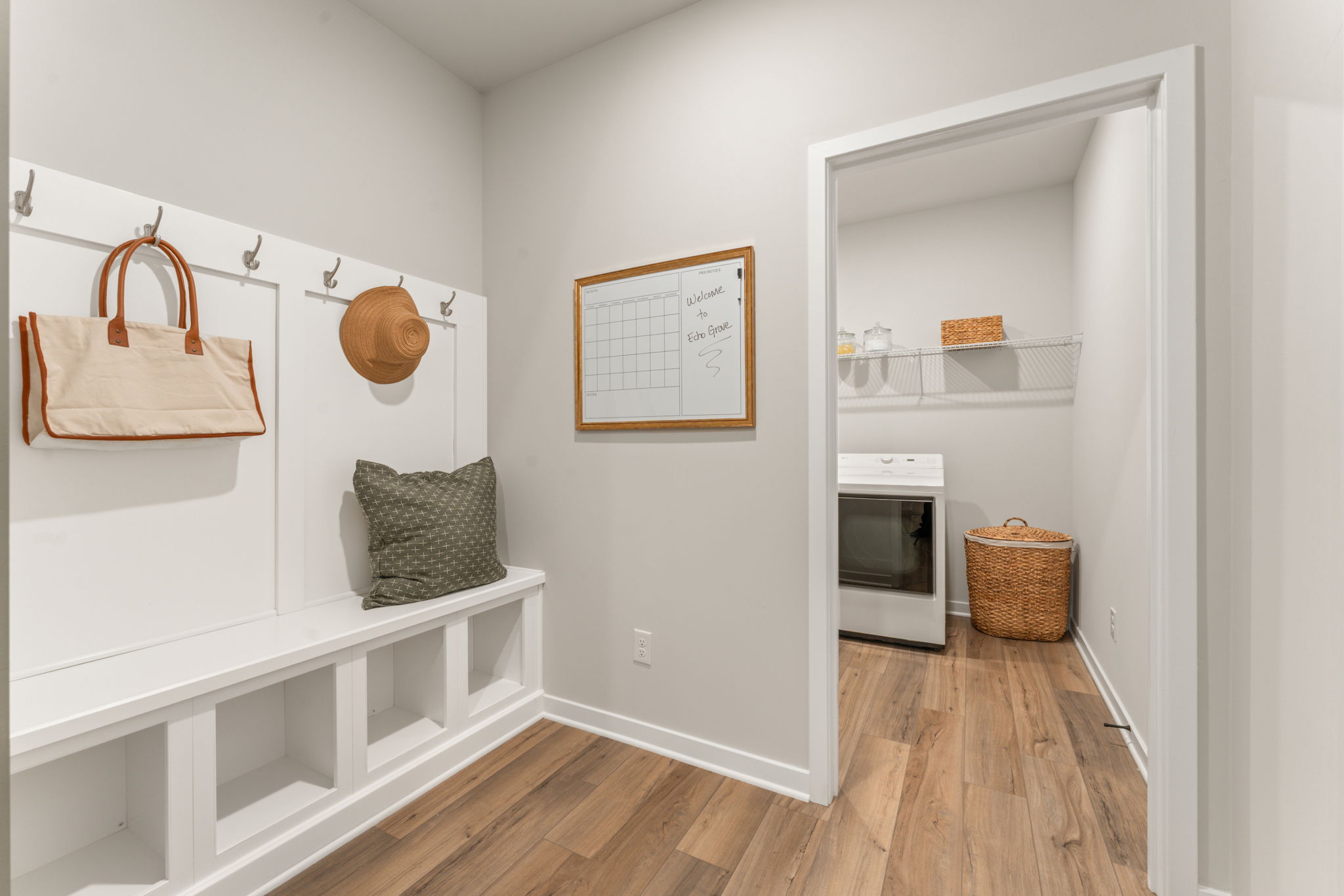 A white room with a white shelf and a basket.