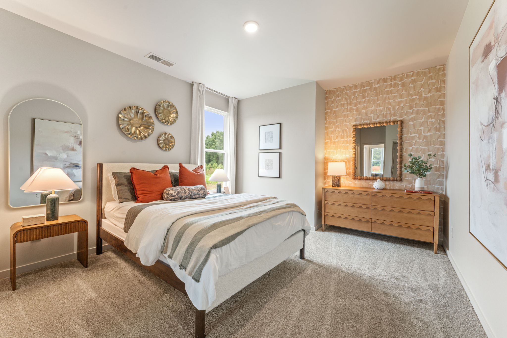 A bedroom with a bed and a mirror.