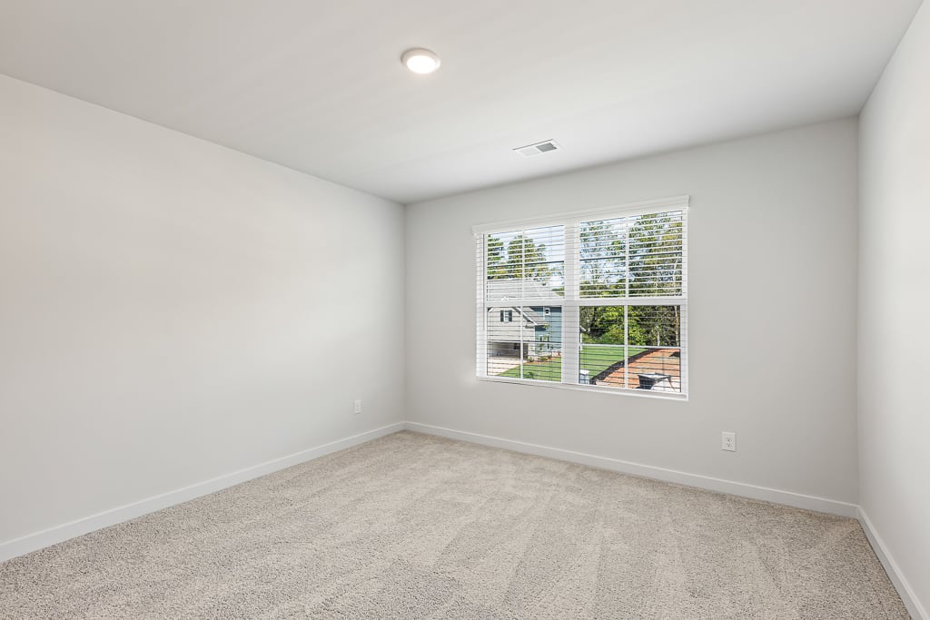 A room with a window and a carpet.