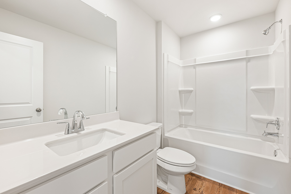 A bathroom with a tub sink and toilet.