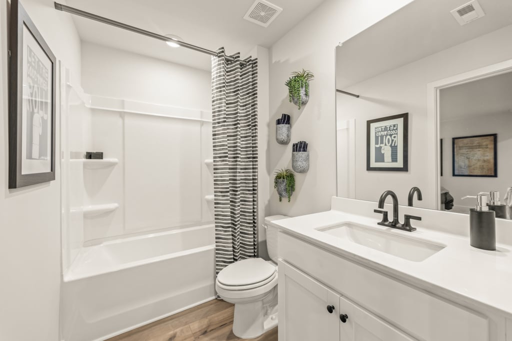 A bathroom with a tub sink and toilet.