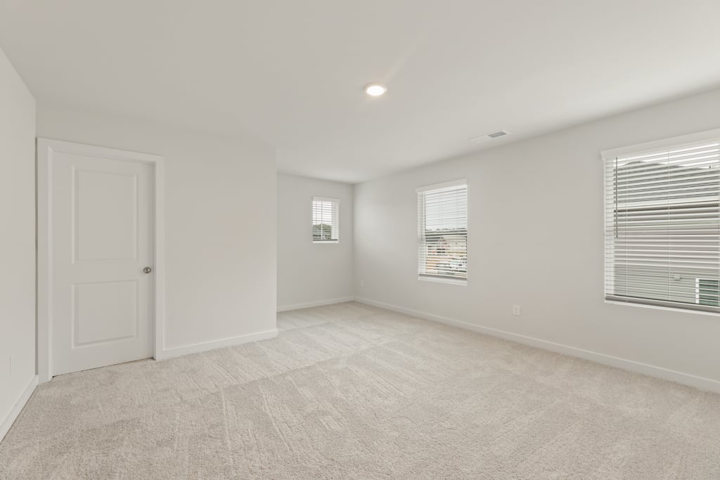 A room with a carpet and windows.