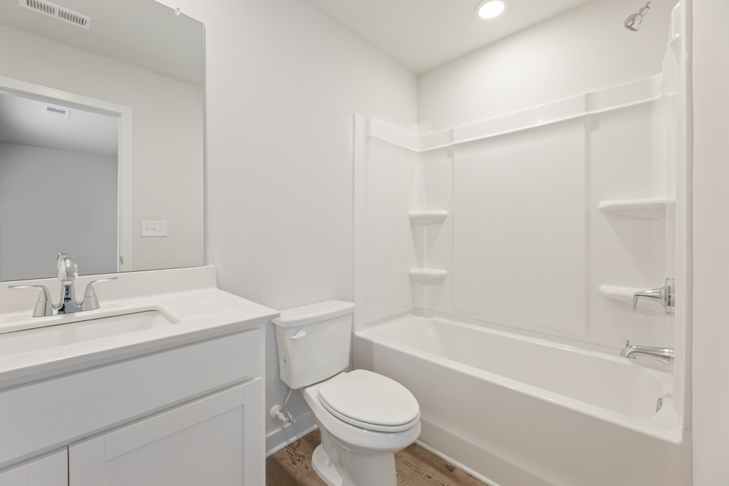 A bathroom with a tub toilet and sink.
