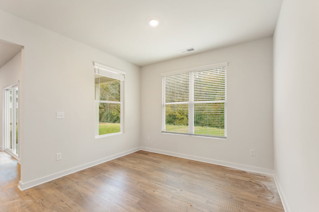 A room with a wood floor and windows.