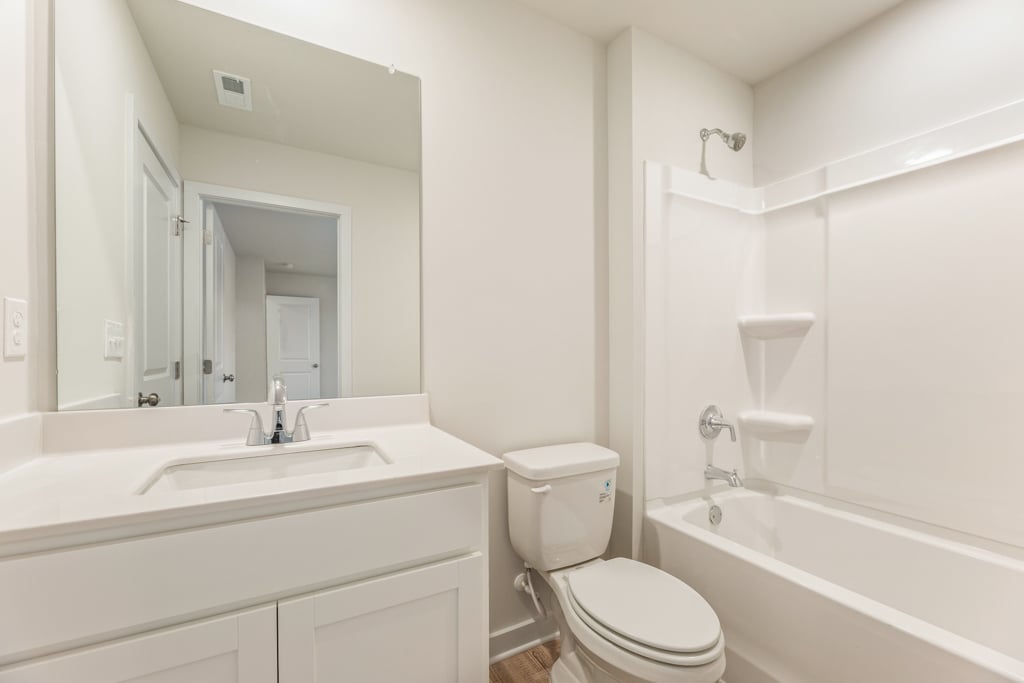 A bathroom with a tub toilet and sink.